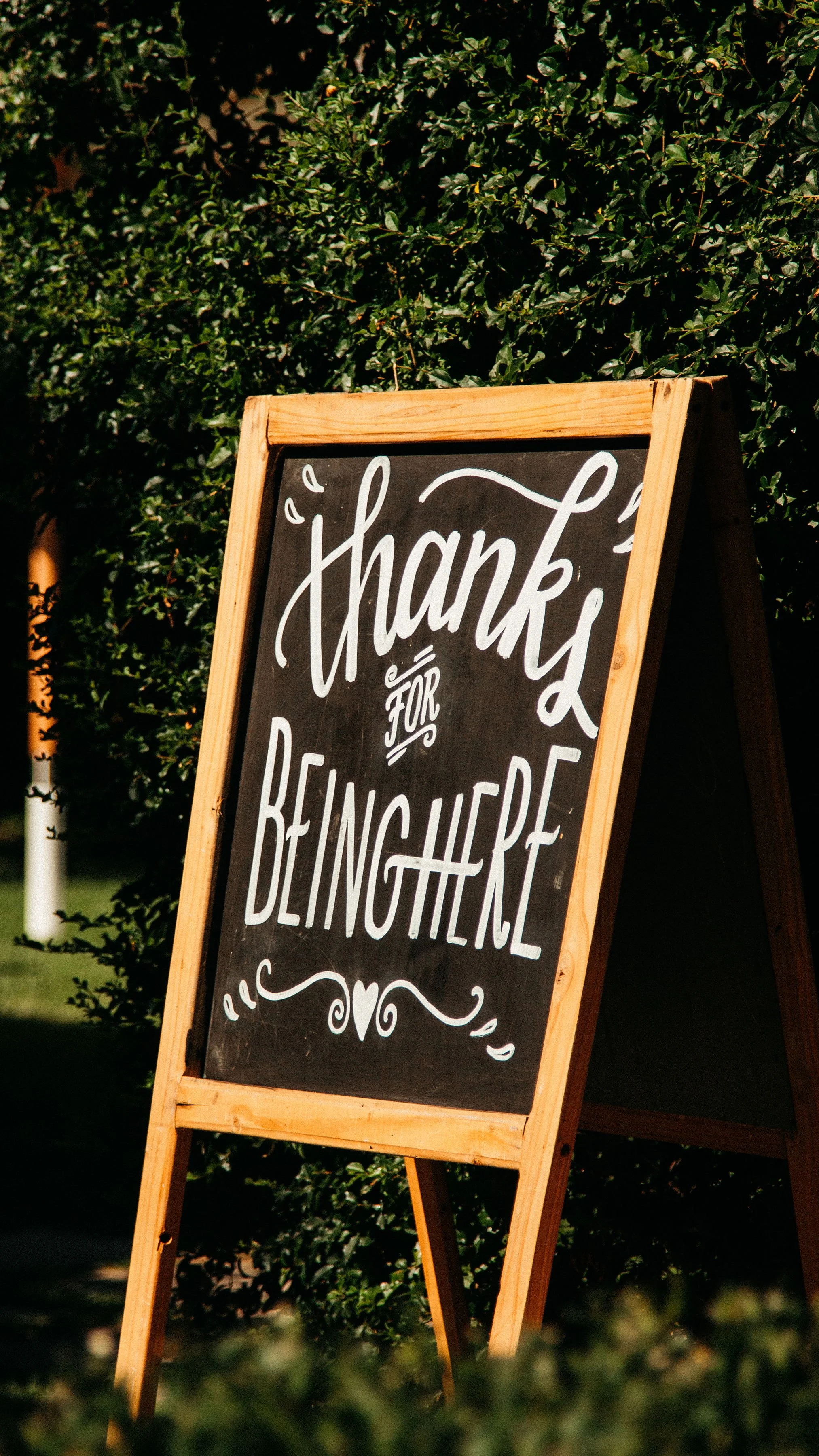 An image of a sign that says "Thanks Be Here" in bold letters with a clean design.