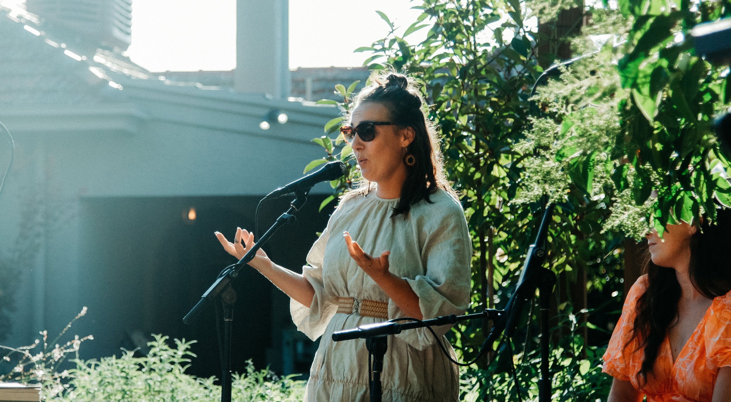 The Secret Garden Gig features a woman in a white dress pouring her heart out into the microphone.