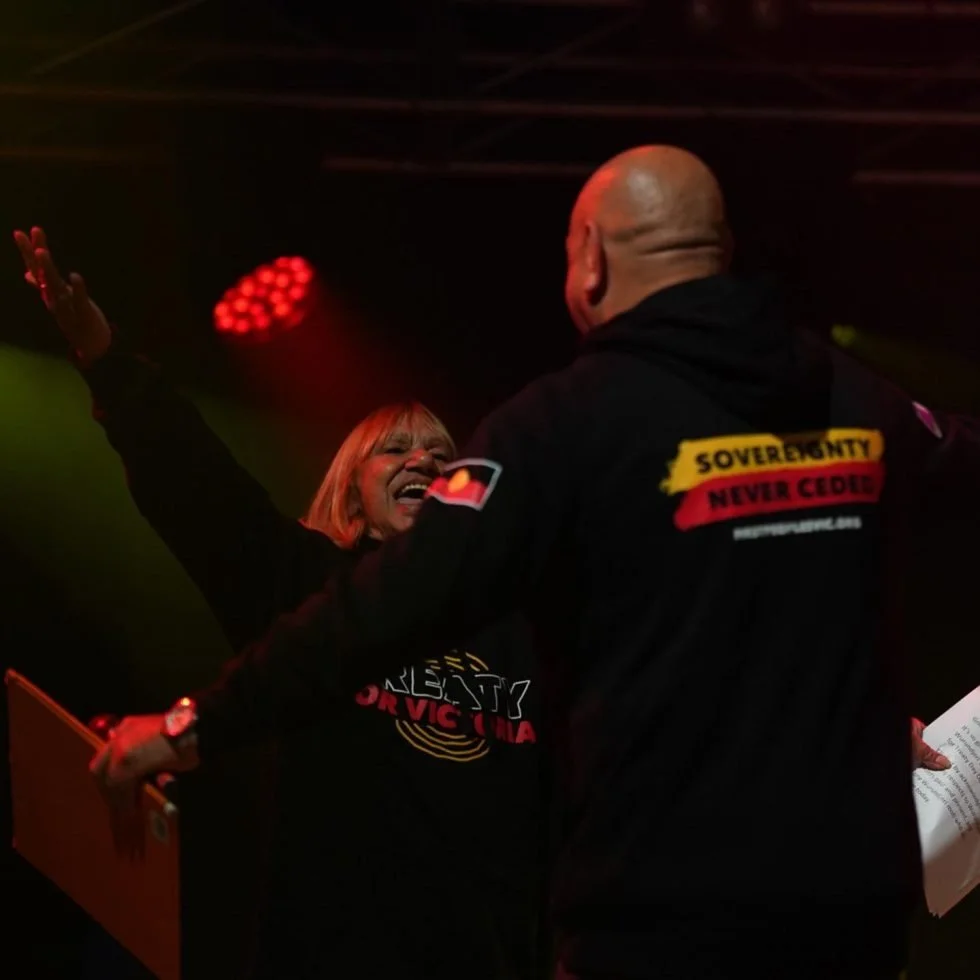Two individuals on stage, one holding a microphone, during the 'Treaty Day Out' event.