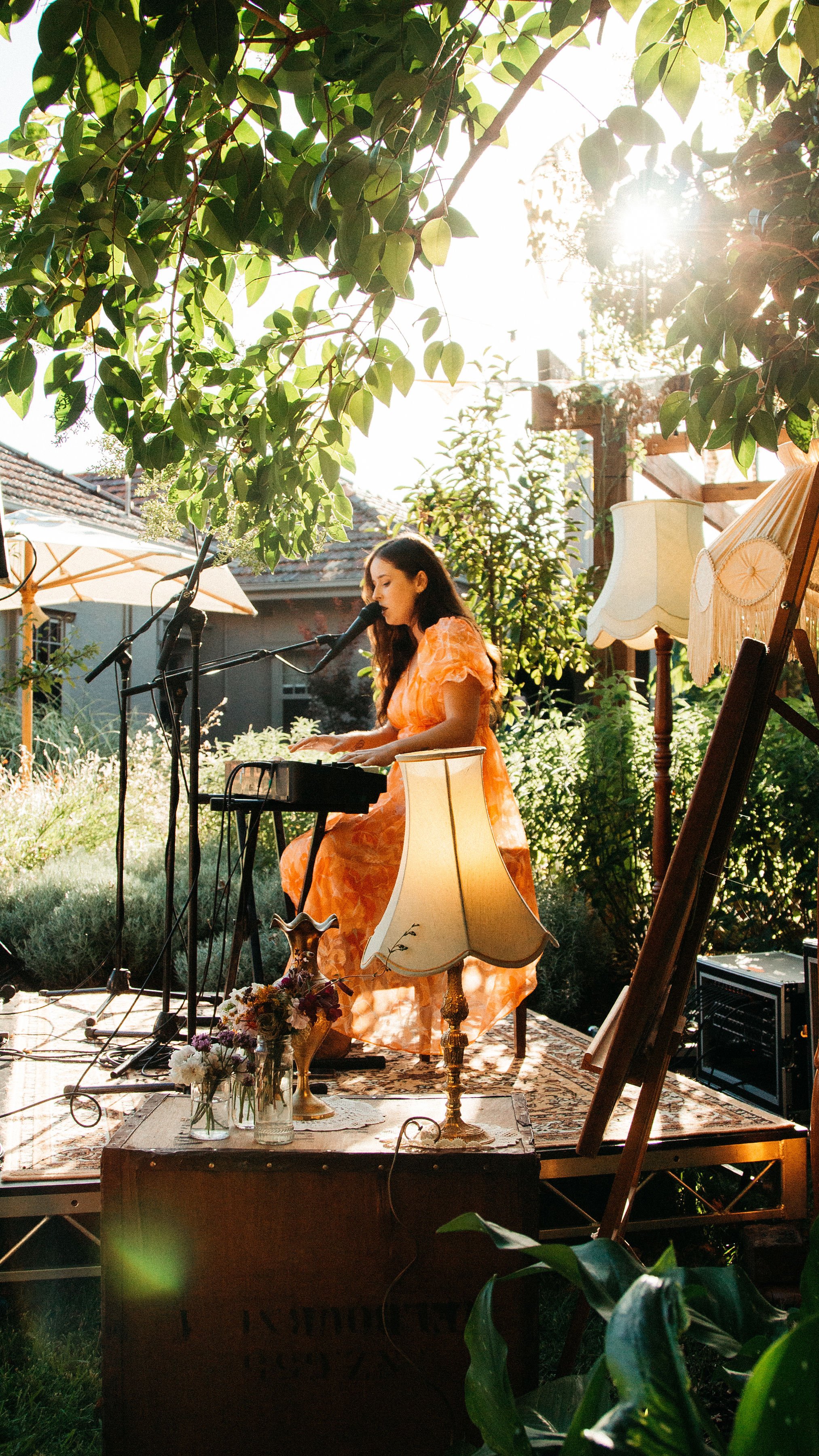 Female musician performing on keyboard outdoors.