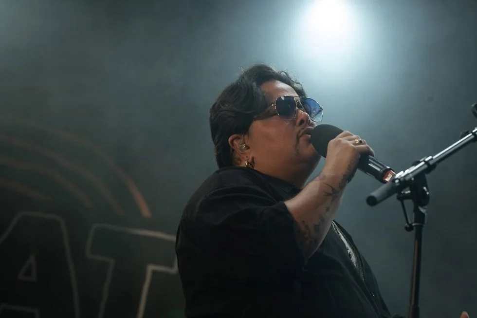 Mo'Ju with sunglasses singing into a microphone at Treaty Day Out.