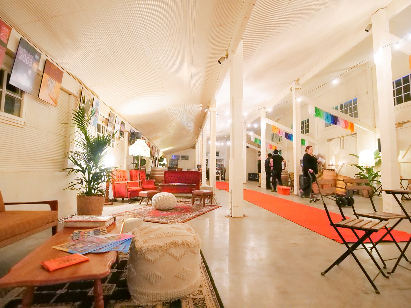 A large event space, with a red carpet, persian rugs and cozy atmosphere.