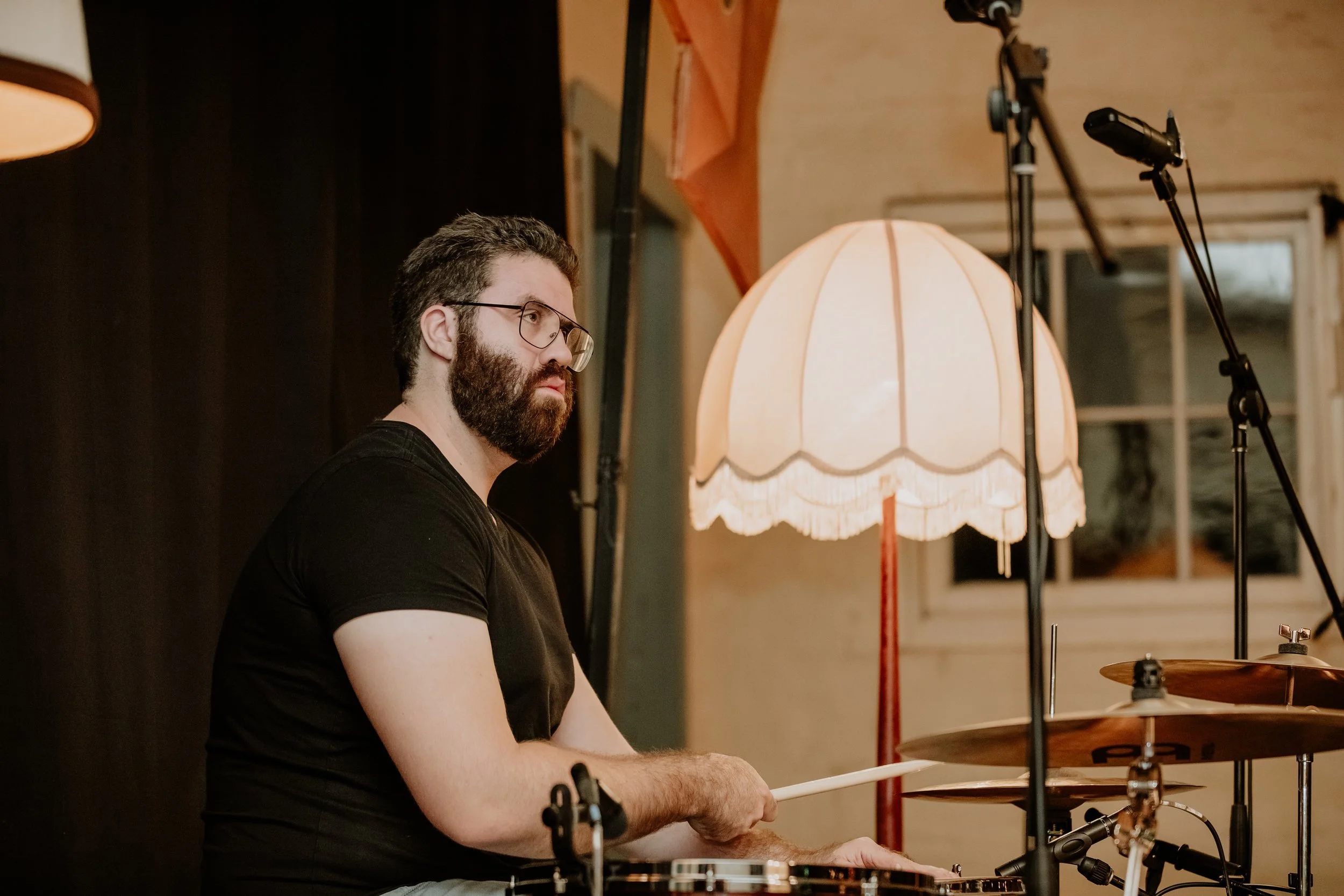 A male drummer plays with the band.