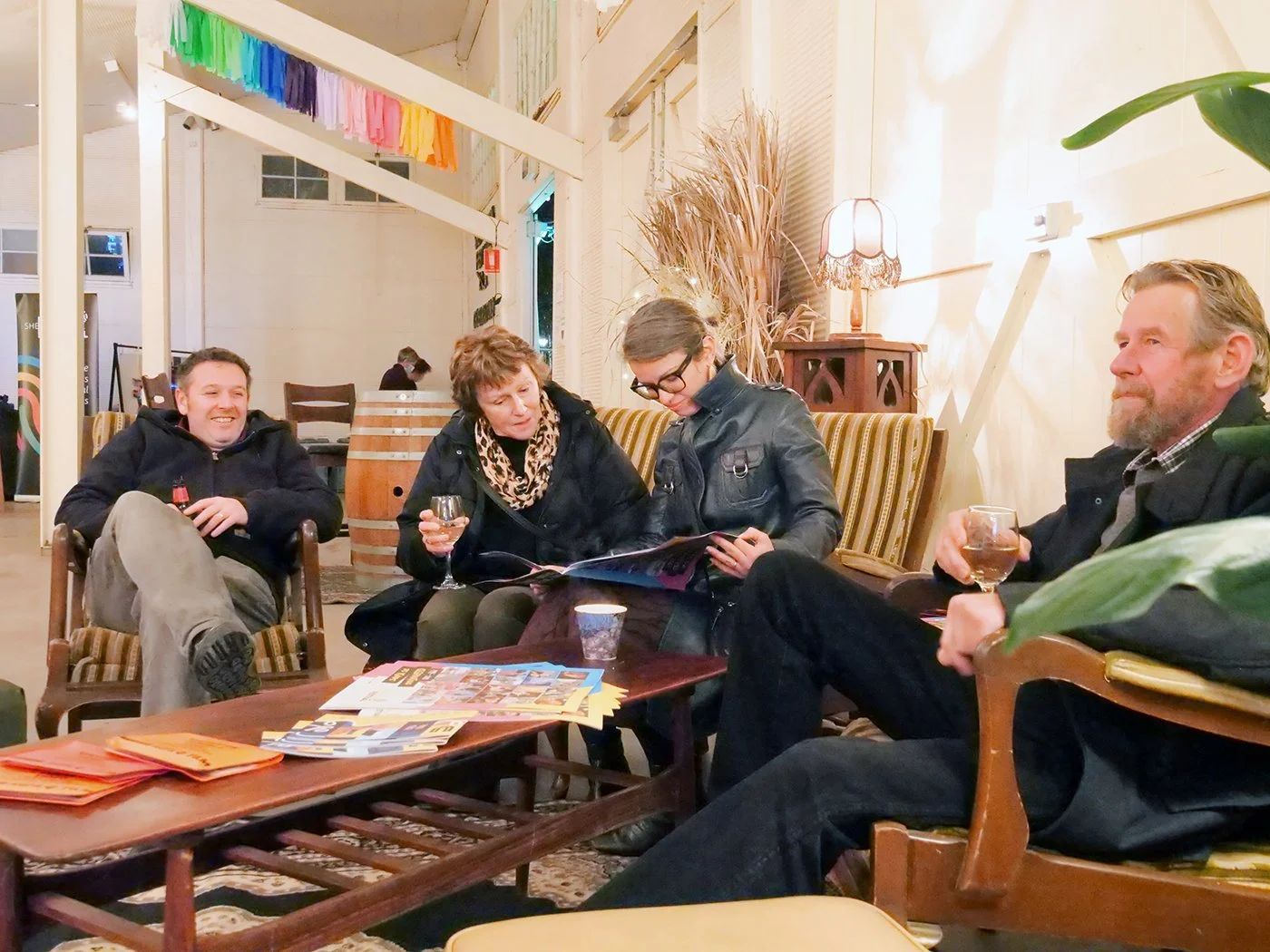 A group of people looking at a book, and enjoying the festival.