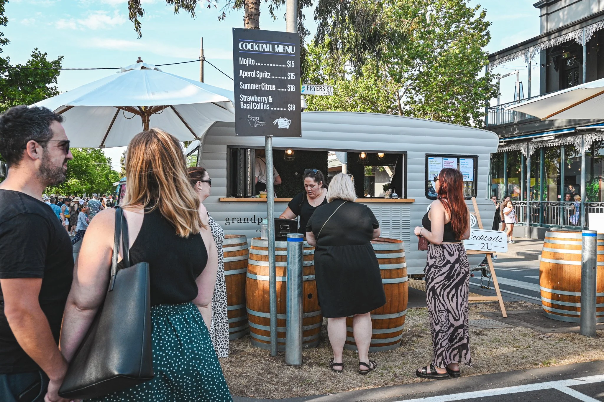People gathered around a food truck, enjoying delicious food and engaging in conversations.