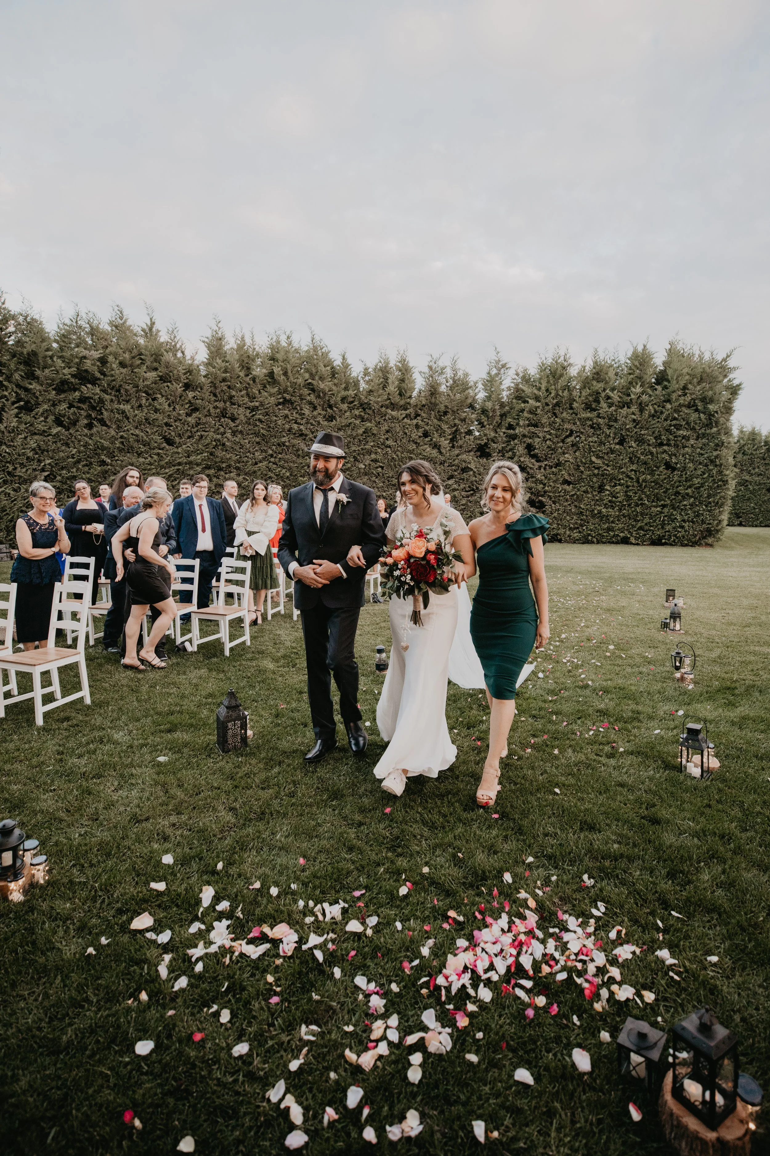 The Bride is walked down the aisle by her parents. 