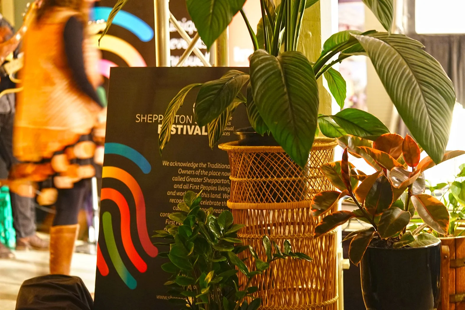 A sign for the Shepparton Festival, surrounded with luscious plants.