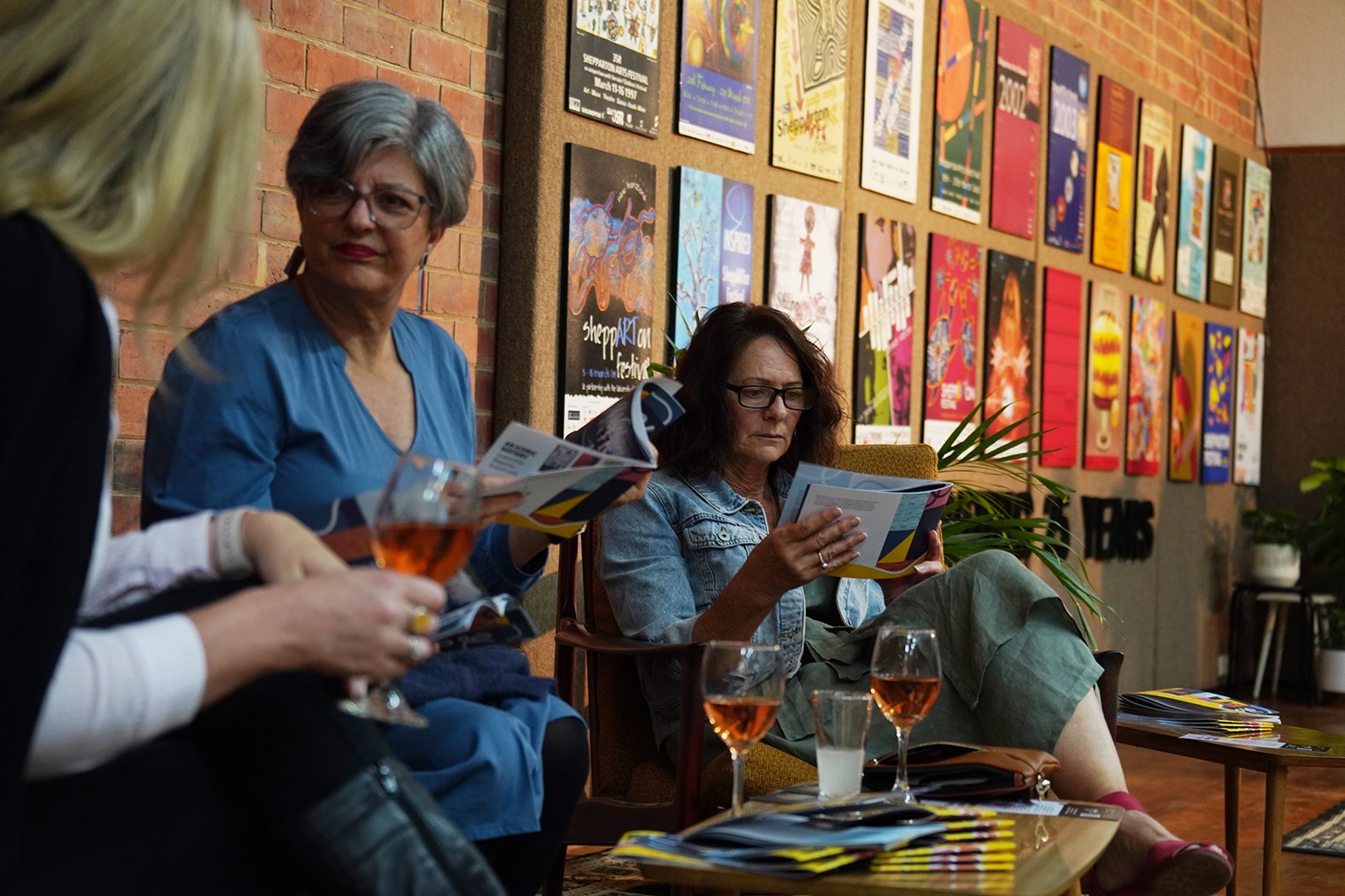 Three women enjoying a drink and reading the Shepparton Festival Guide.