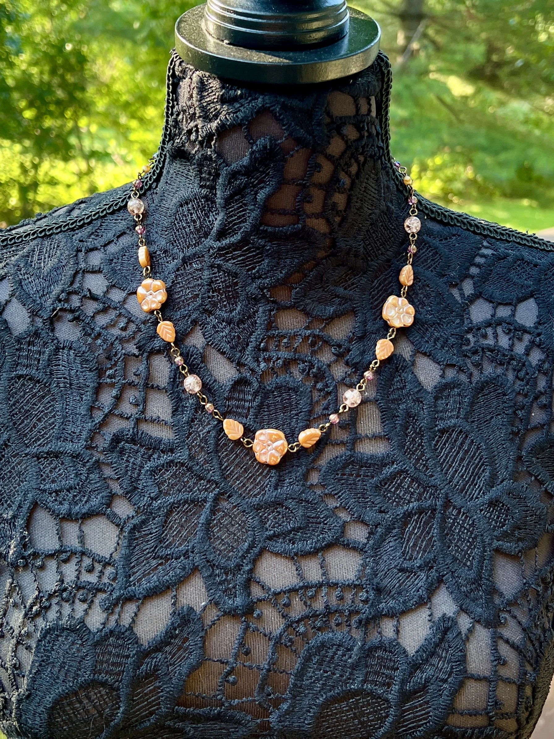 Handmade Czech glass necklace with amber and gold pressed beads and leaf accents.