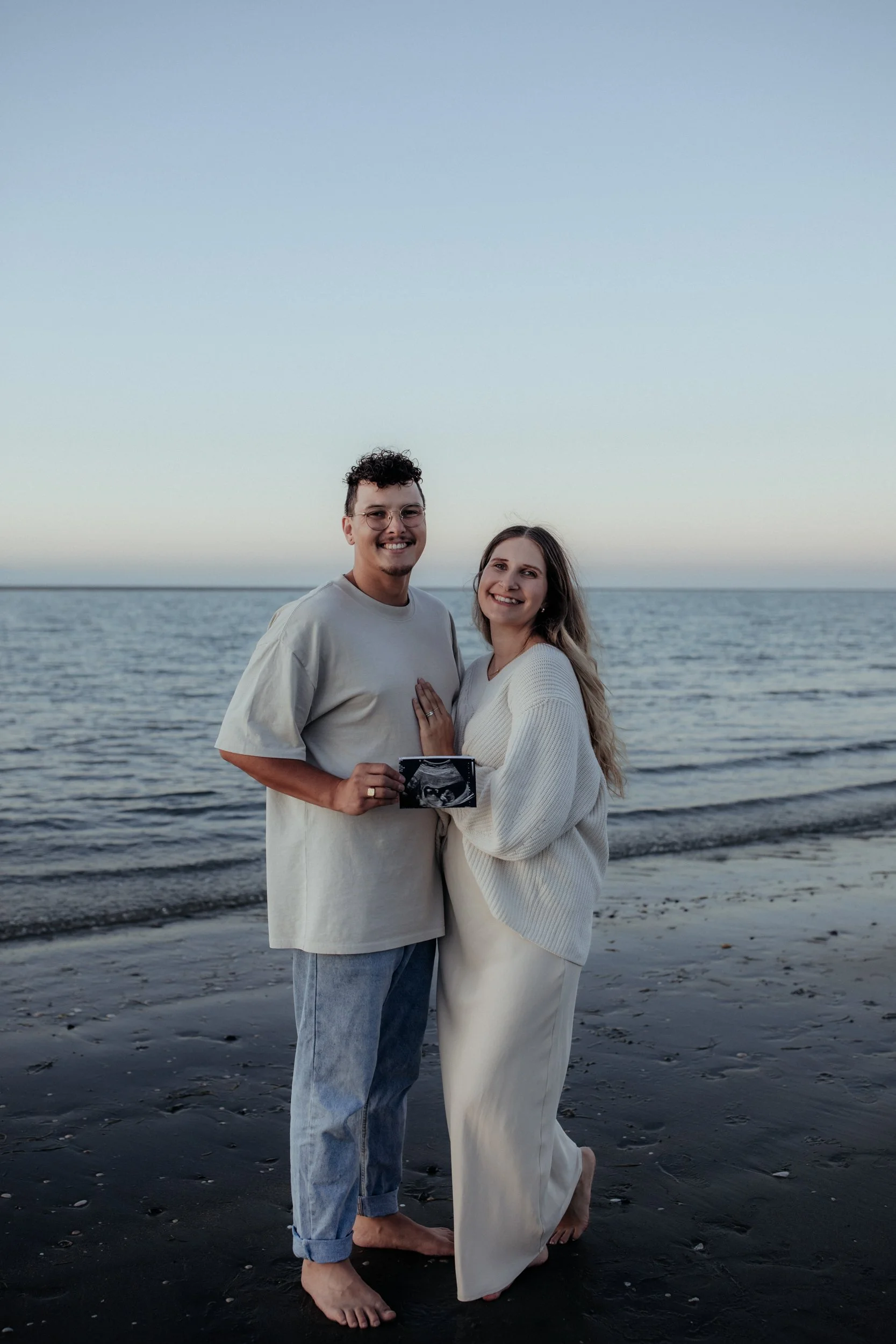 Expectant parents hold ultrasound at maternity photoshoot in Nelson, New Zealand.