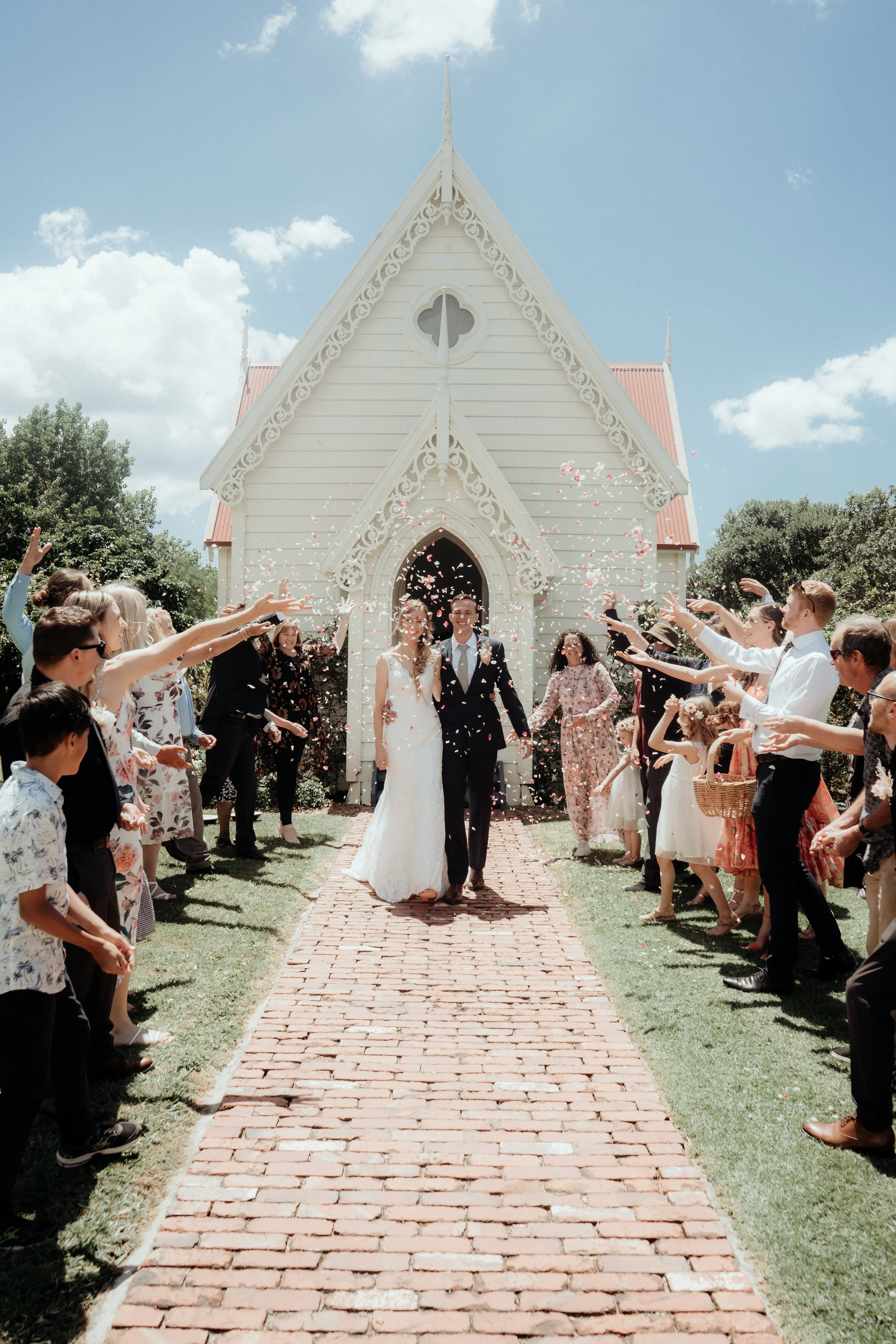 Newlywed couple exiting church at Matakana wedding.
