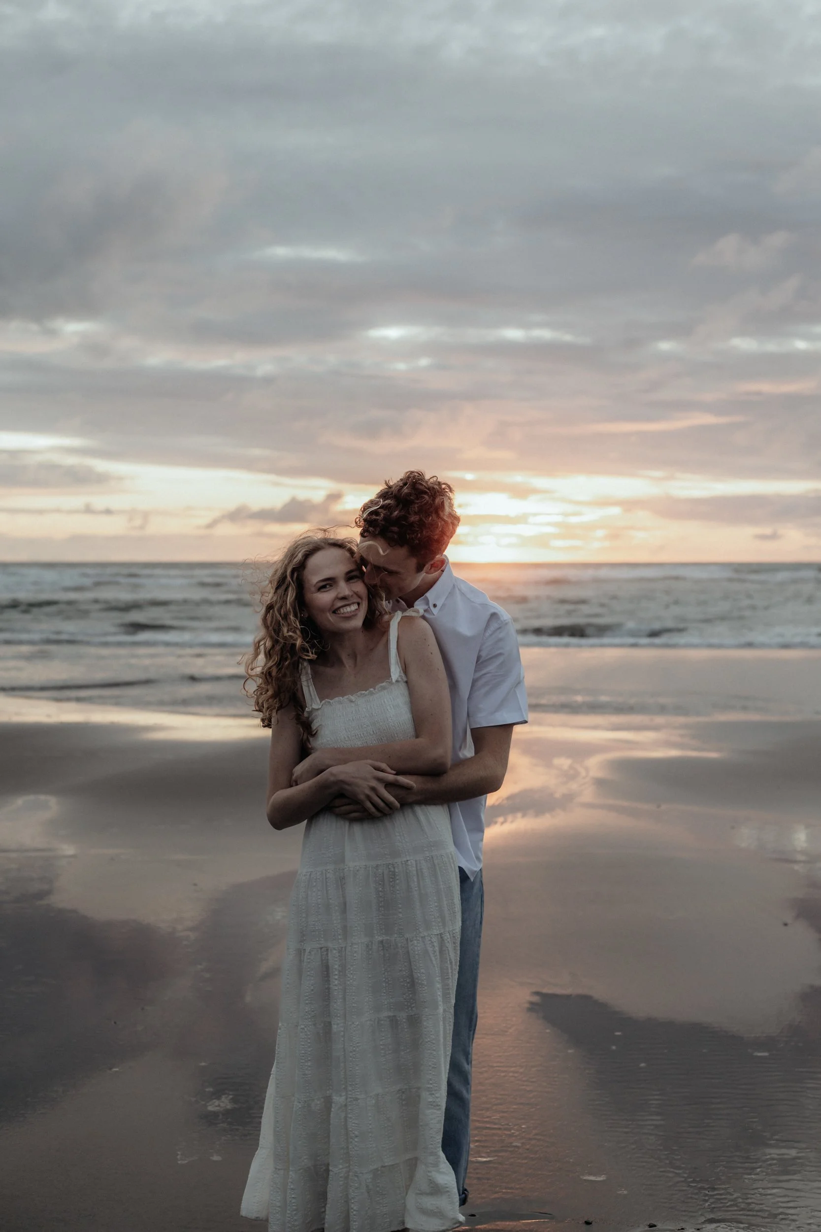 Romantic engagement photography in natural New Zealand landscape at Piha Beach.
