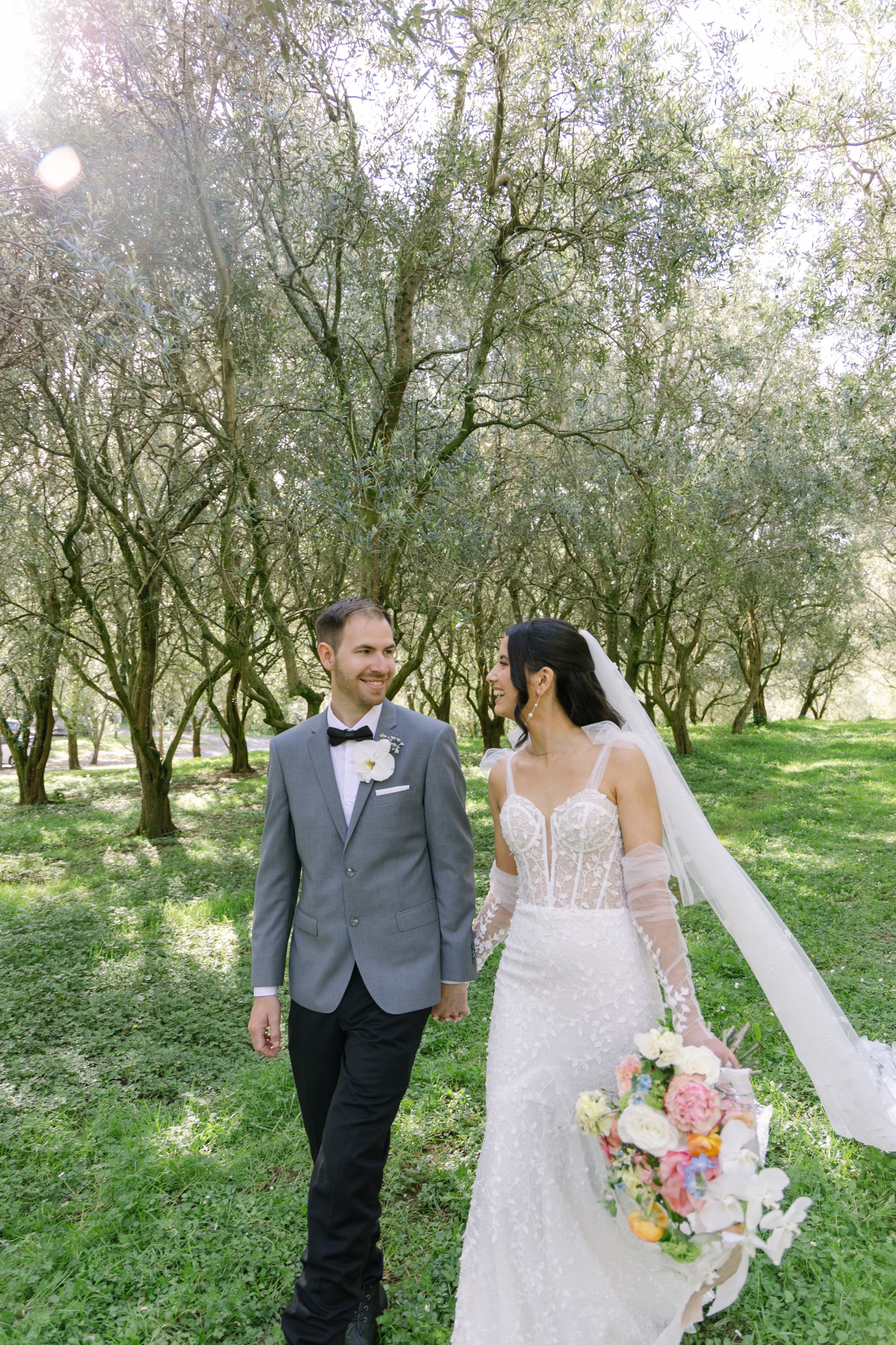 Newlywed couple walking in an olive grove at Bracu Estate Wedding, Auckland.