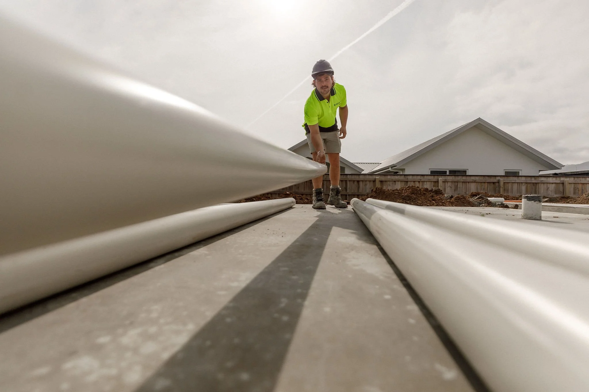 Drainlayer picking up PVC pipe - Chethams & Co Drainlaying.jpg