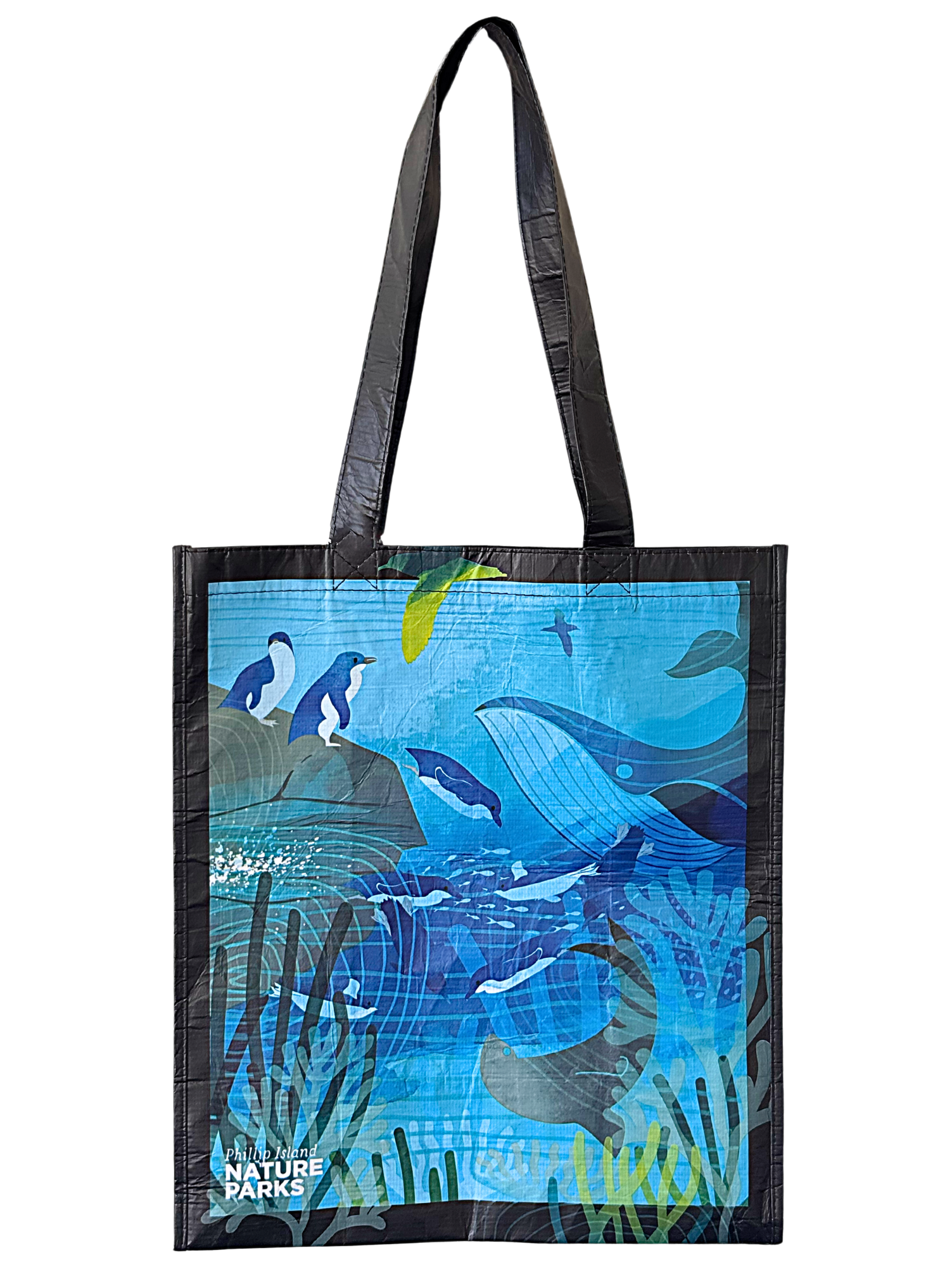 Reusable tote bag with an illustration of a whale, penguins, and sea plants in a blue ocean scene, labeled 'Philip Island Nature Parks'.