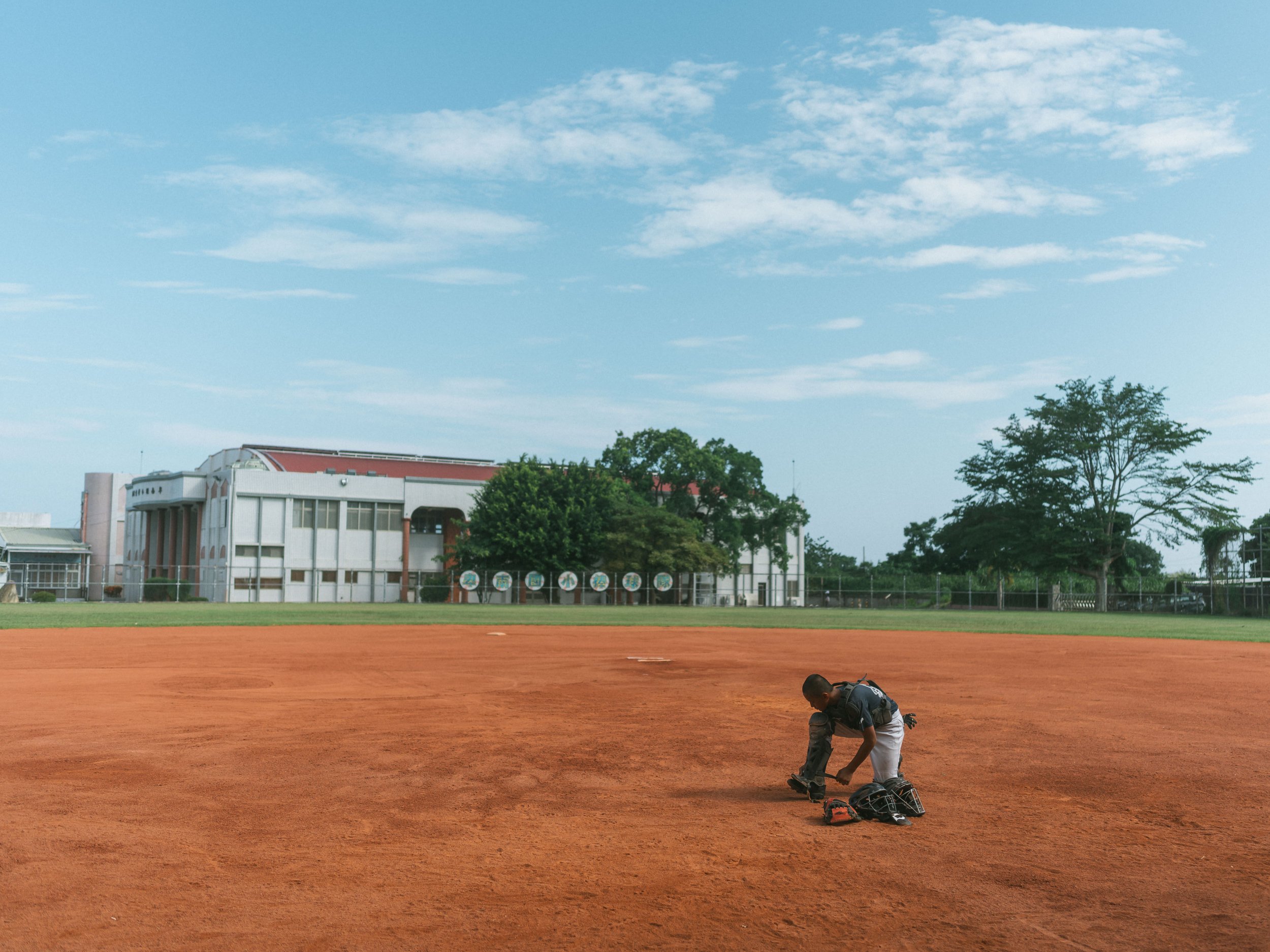 Capitain Yeh from Team A of Bei-Nan Elementary puts on the catcher's gear before training.