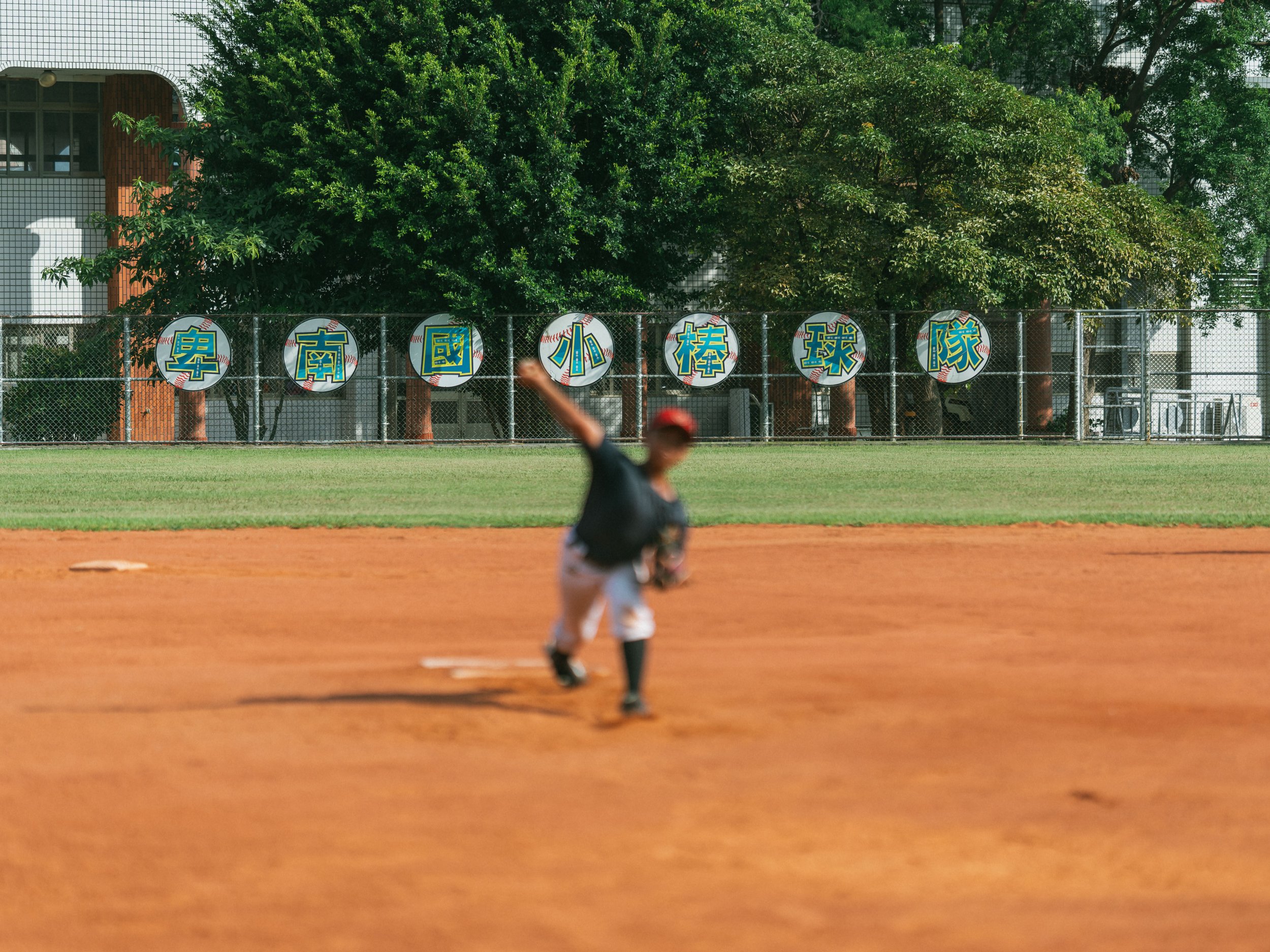 The name of the school is visible in the background of the baseball field.