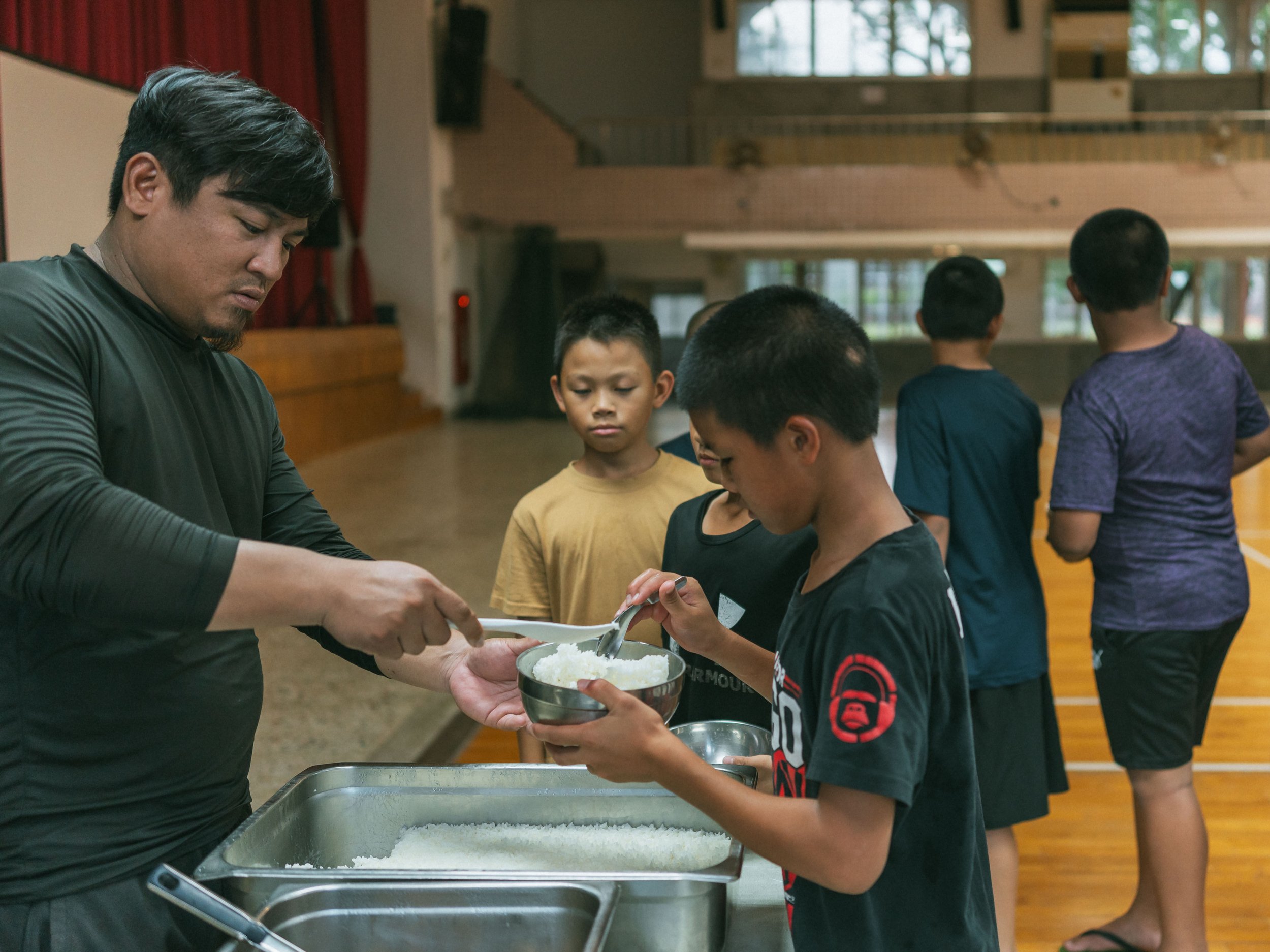 The children in the boarding school receive their dinner.
