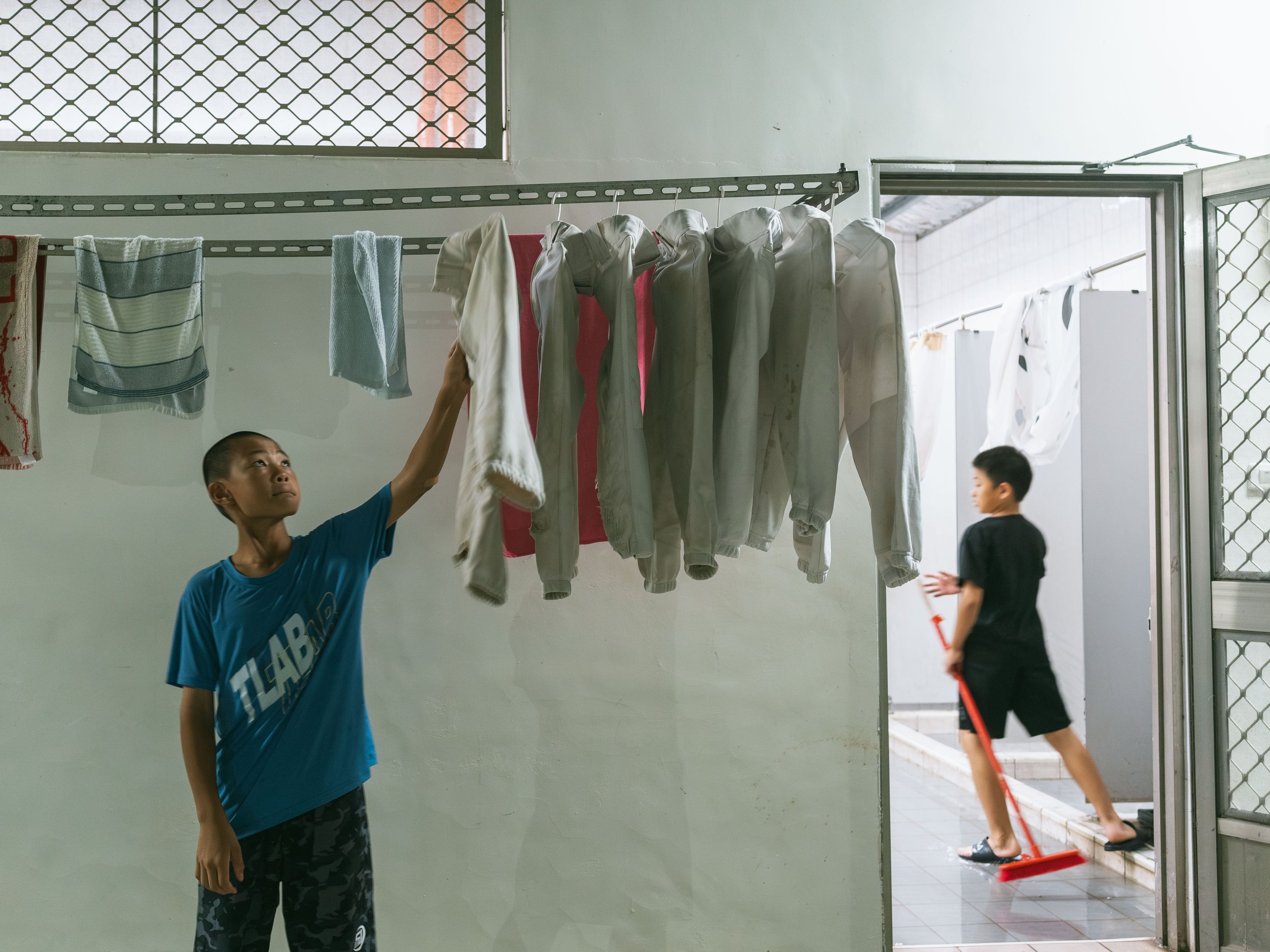 The children from the baseball team who stay at the boarding school are moving the evening meal.
