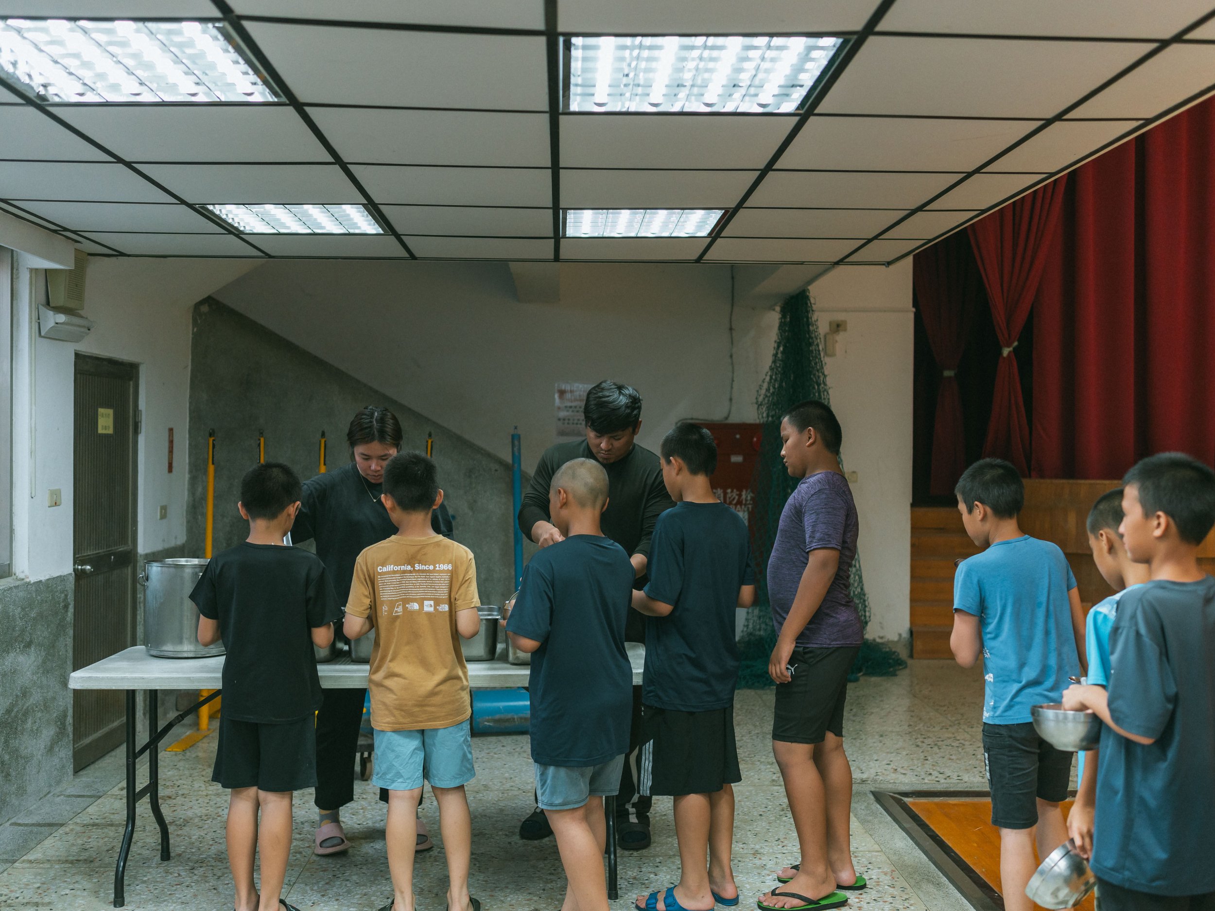The children in the boarding school receive their dinner.