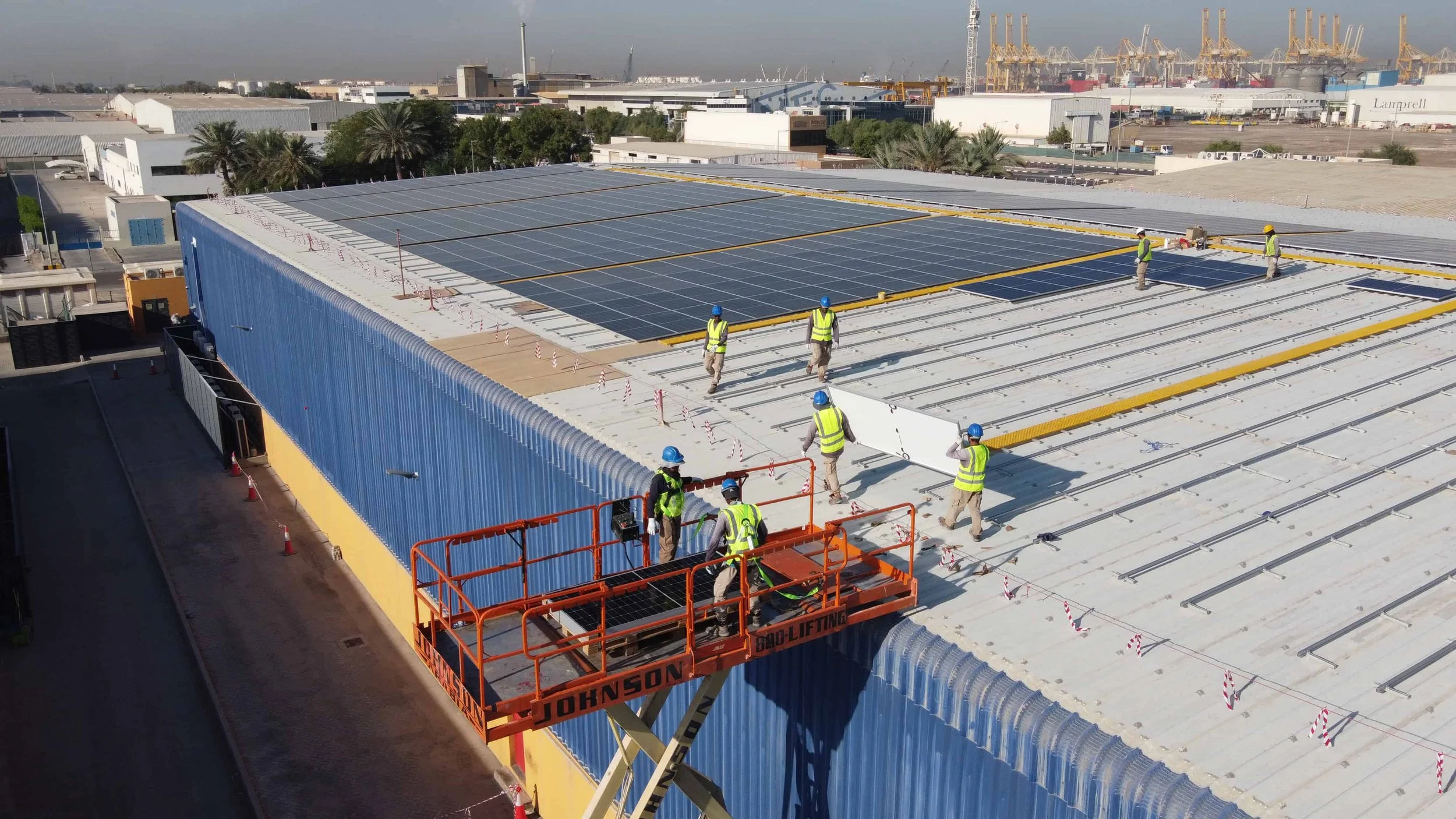 Drone Photo of Workers Installing Solar Panels on Roof.jpg