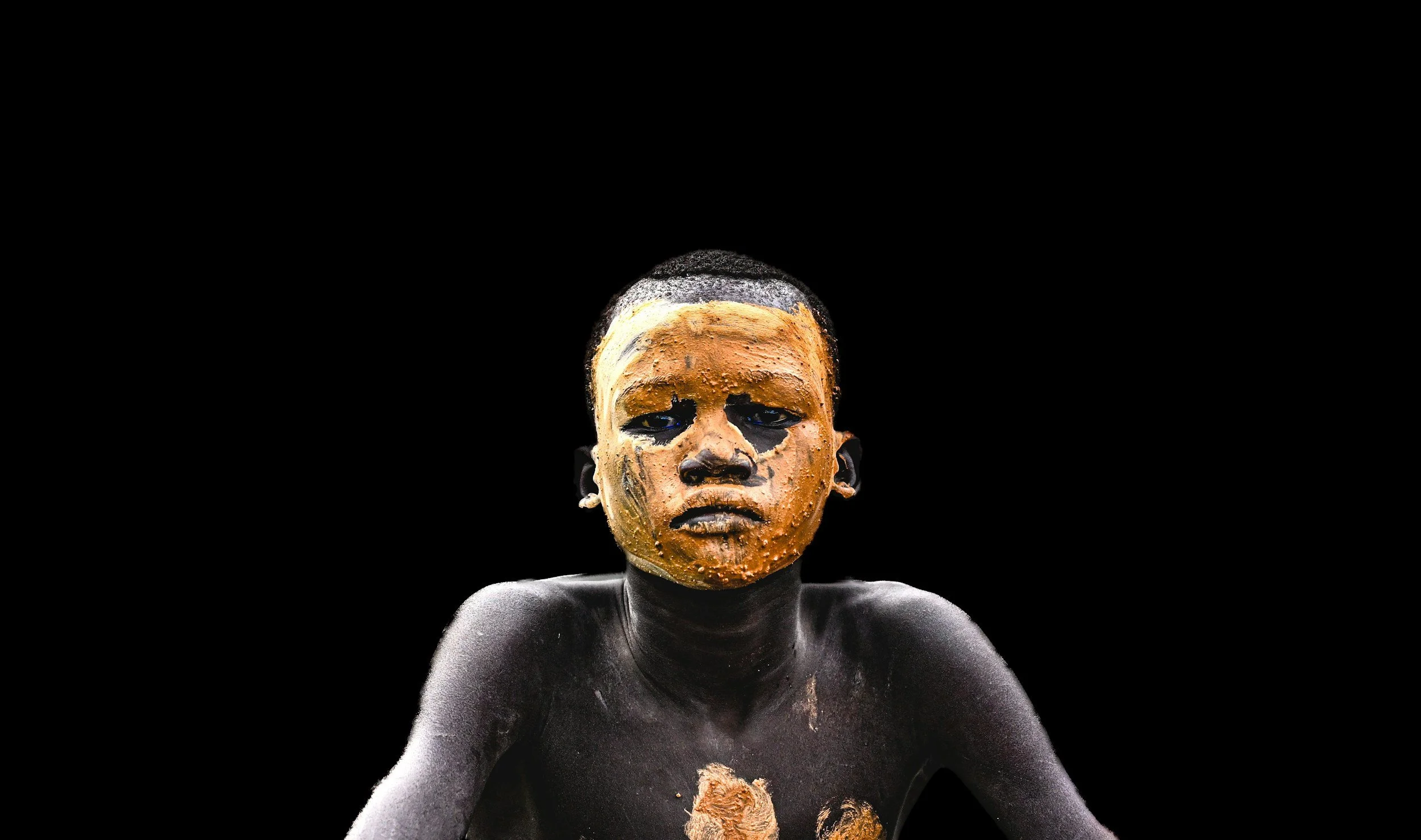 A silhouetted humanoid figure standing on a textured surface with a large, glowing, orange-yellow setting sun in the background, under a dark sky.