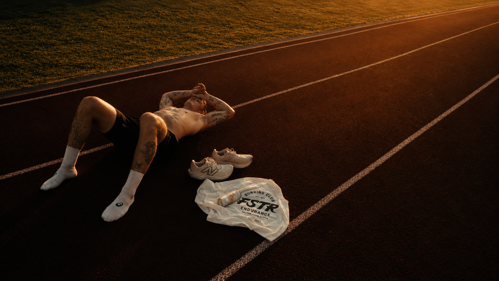 FSTR Endurance Running Club brand identity in use — a lifestyle shot of a runner on a red track at golden hour with branded FSTR Endurance apparel, showcasing the visual identity in an athletic context.