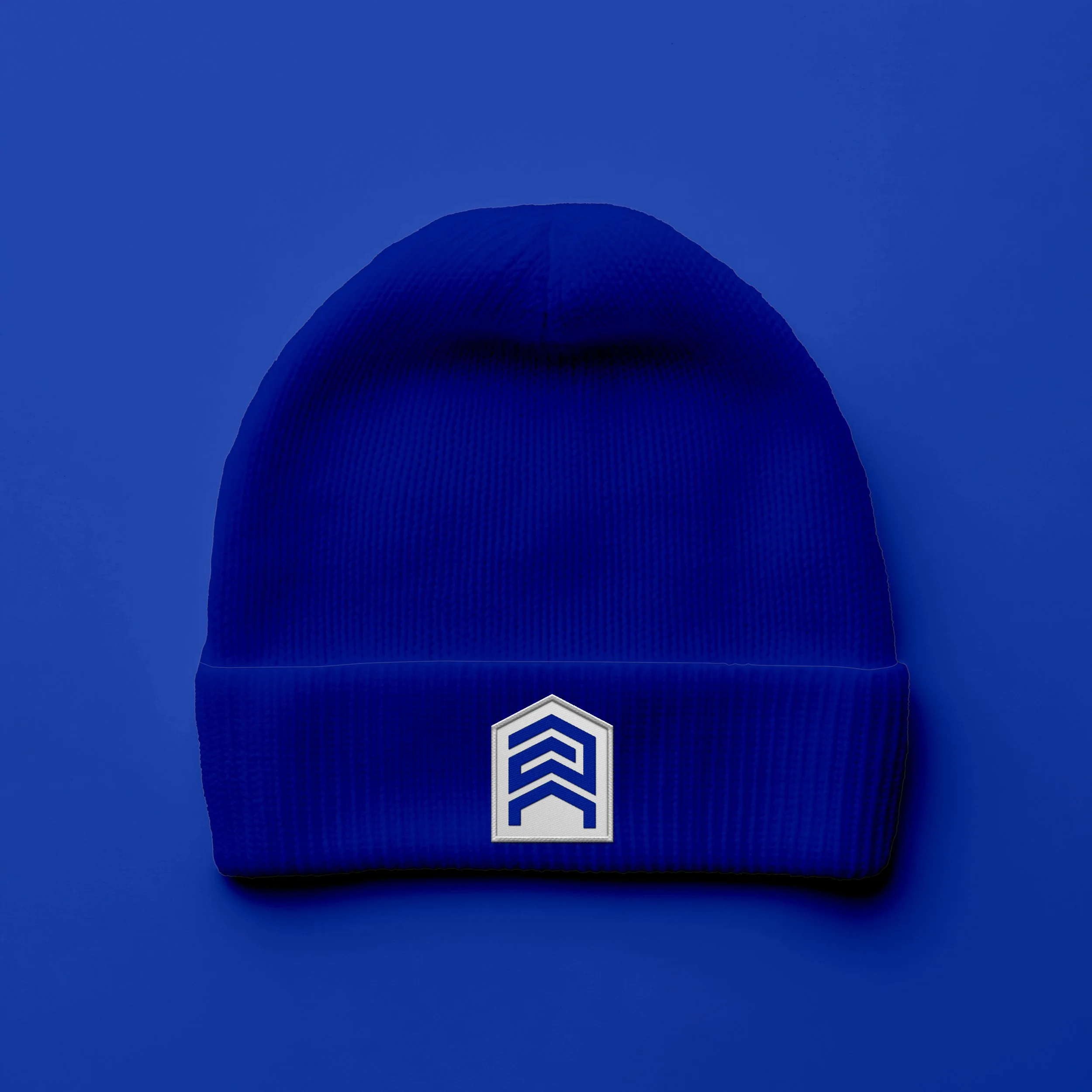 Electric blue Apex Team toque with white logo embroidered on the cuff — branded real estate promotional merchandise designed by So Very Madly.