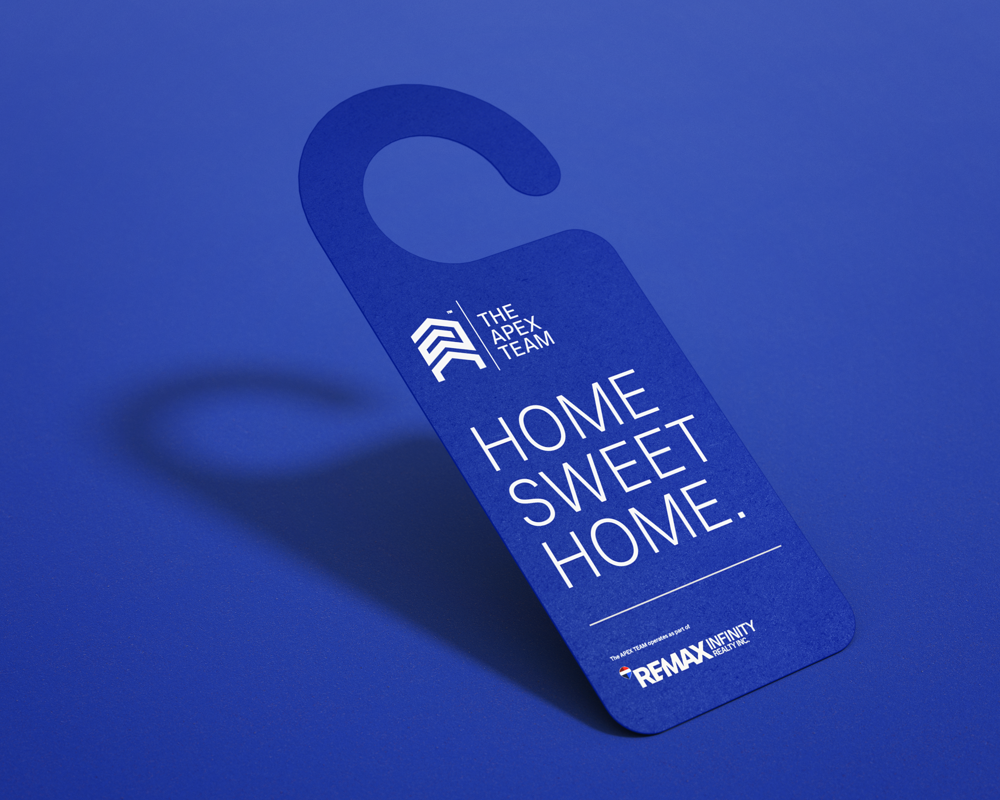 The Apex Team branded door hanger in electric blue with "Home Sweet Home." in white — real estate print collateral designed by So Very Madly.