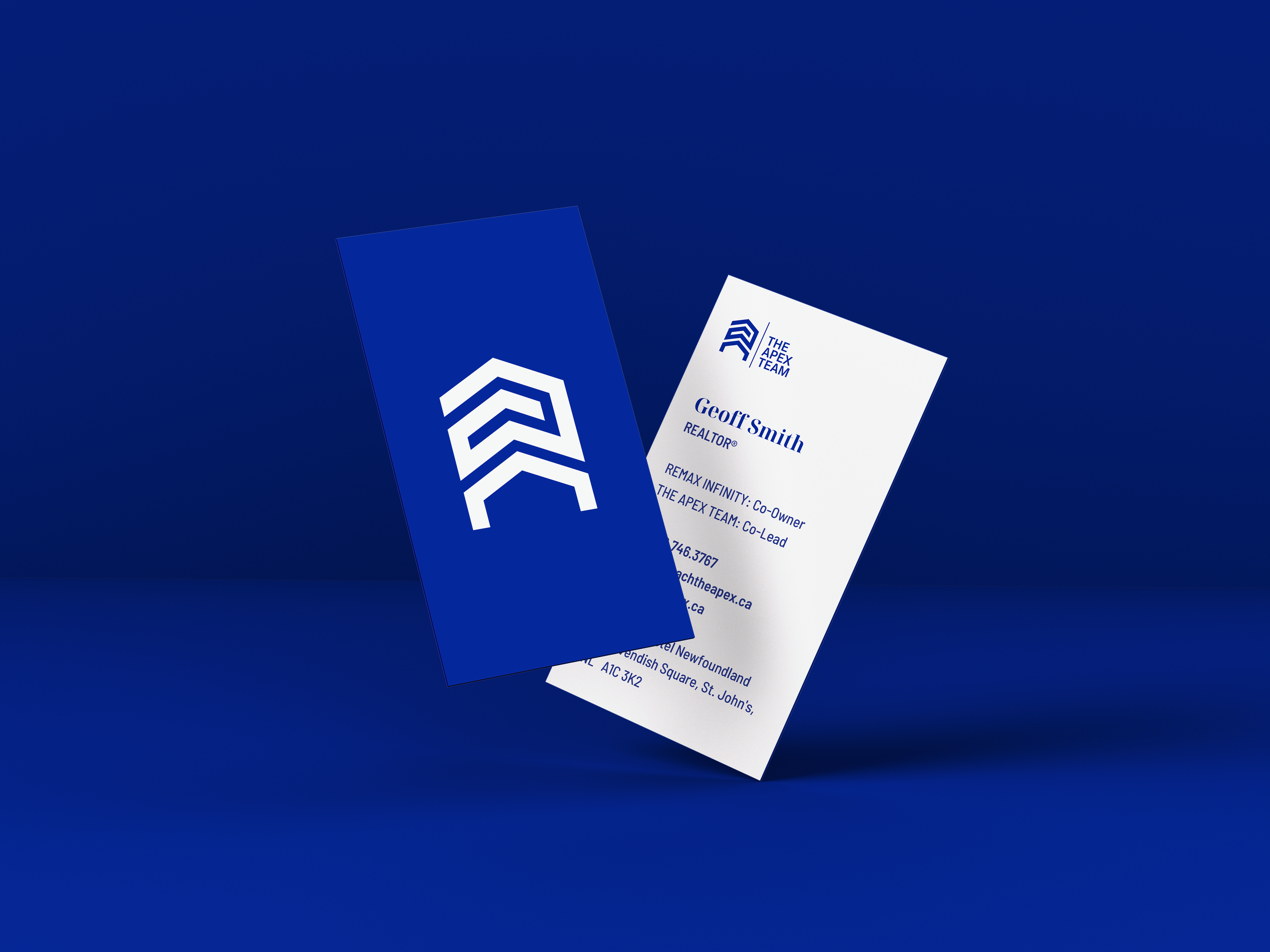 The Apex Team business cards — blue card with white logo and white card with navy logo and contact details, standing upright on a deep blue background.