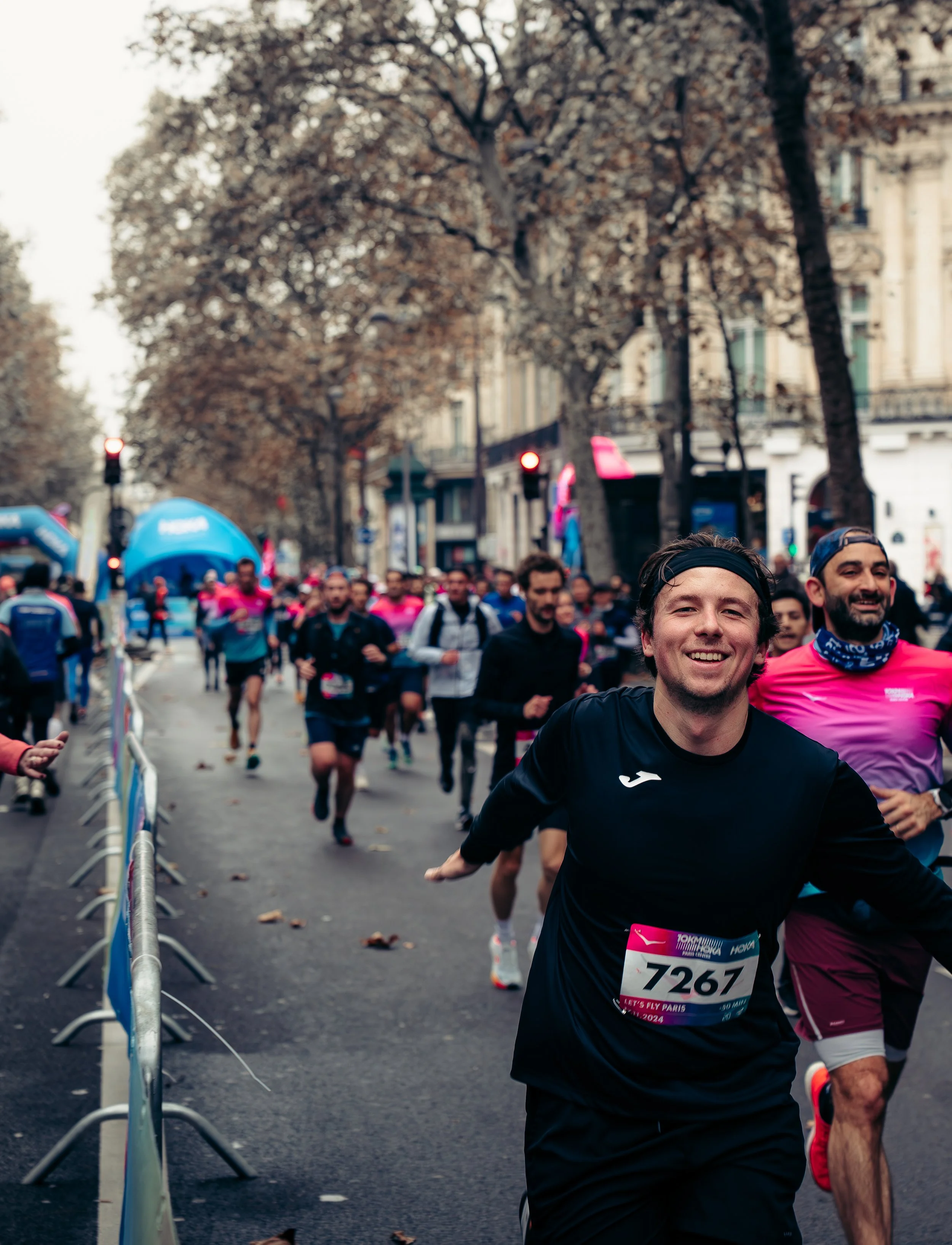 Group of runners participating in a marathon on city street, smiling and enjoying the race.