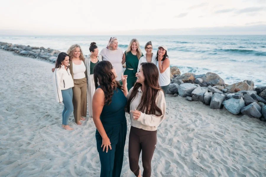 Jazmin Cornejo with Bizz Bitch Community members connecting and laughing together during a beach retreat focused on women entrepreneurs and community.