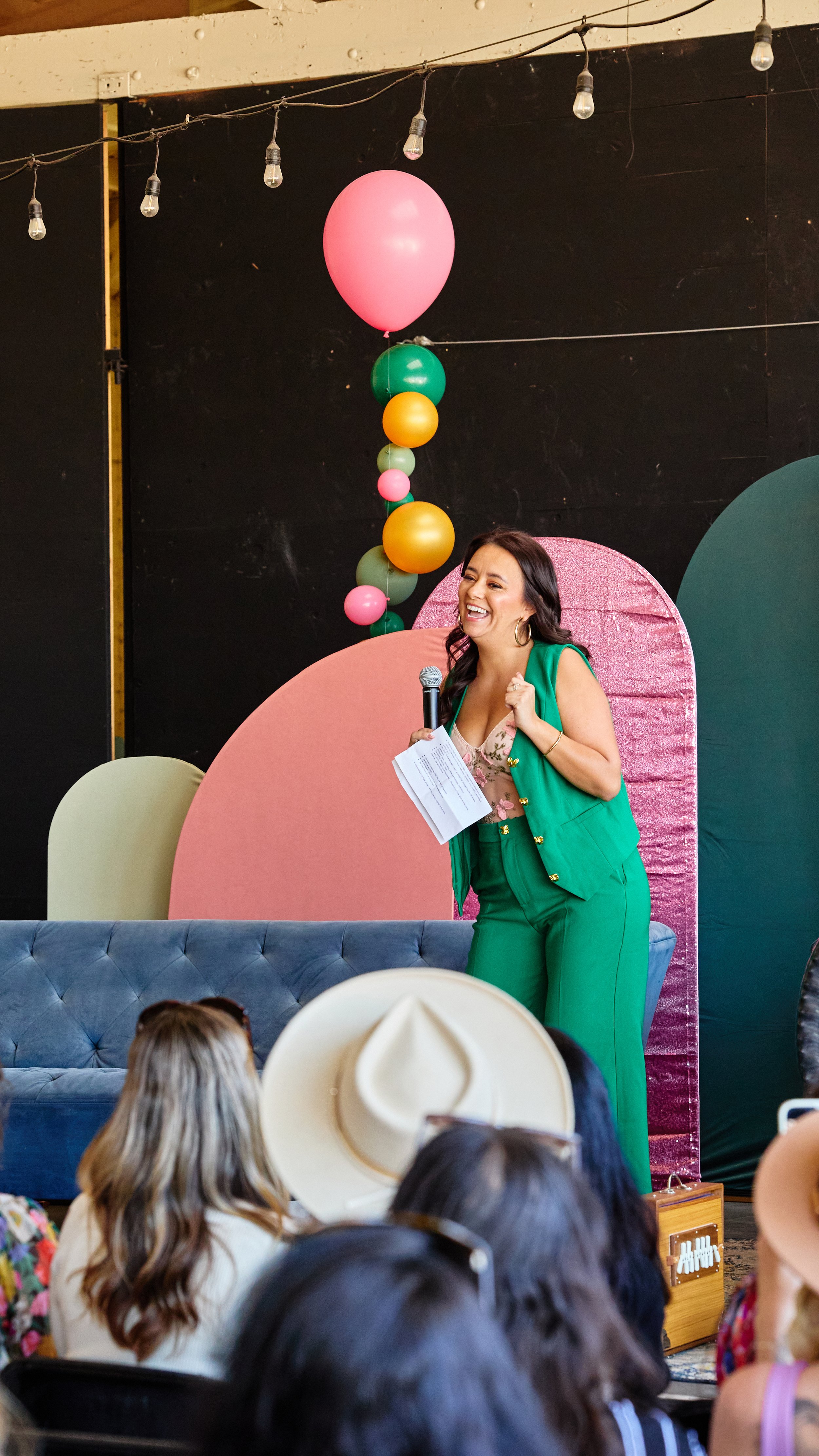 Jazmin Cornejo, founder of Bizz Bitch Community, speaking on stage at an entrepreneur event, sharing insights with an audience while building connections through community and leadership.
