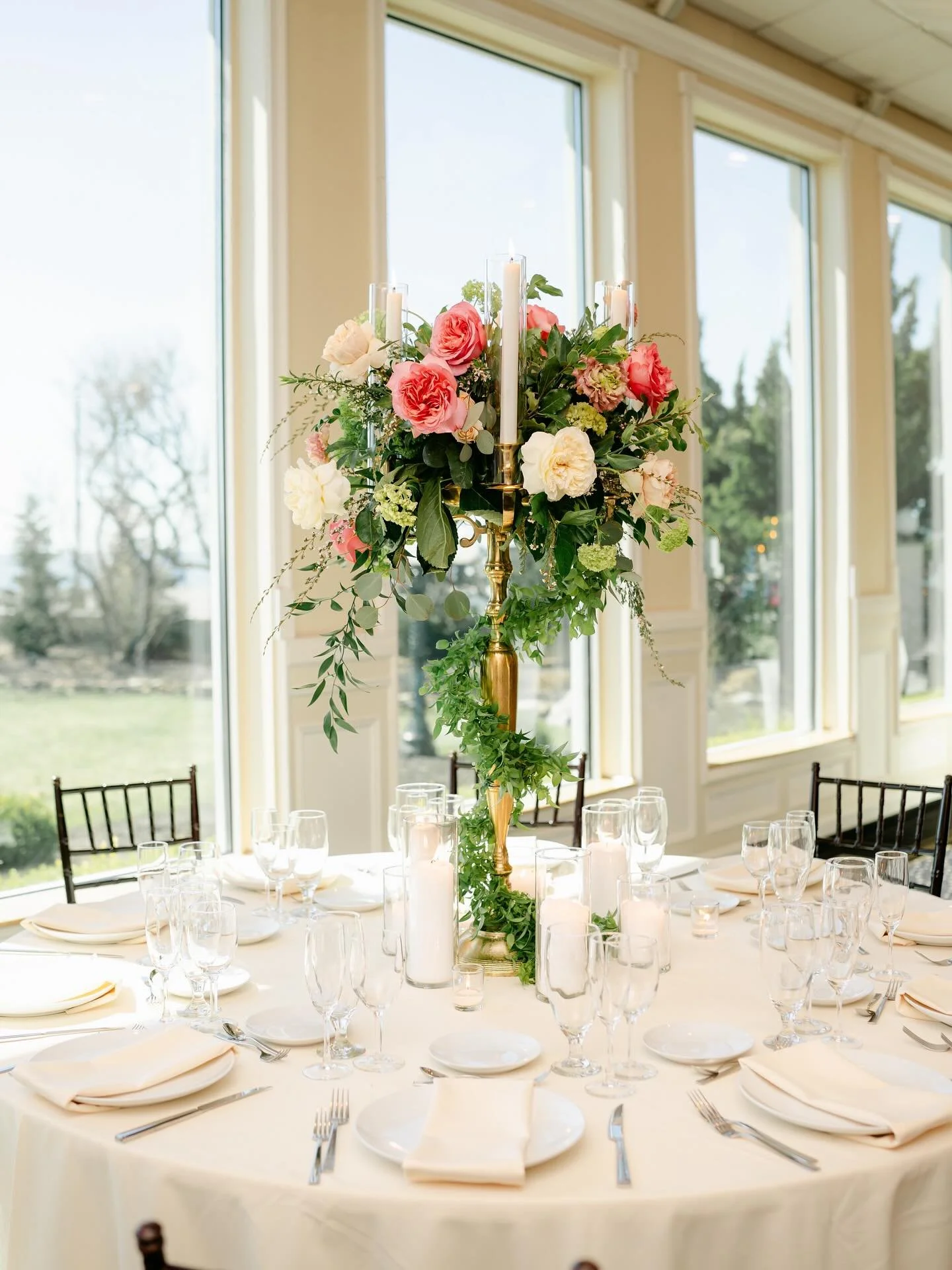 A fresh twist on the classic high centerpiece and candelabra ✨
Created by our talented floral designer Maria, this gold candelabra is adorned with lush greenery, romantic blooms, and taper candles on top for a timeless yet modern look. Perfect for ma