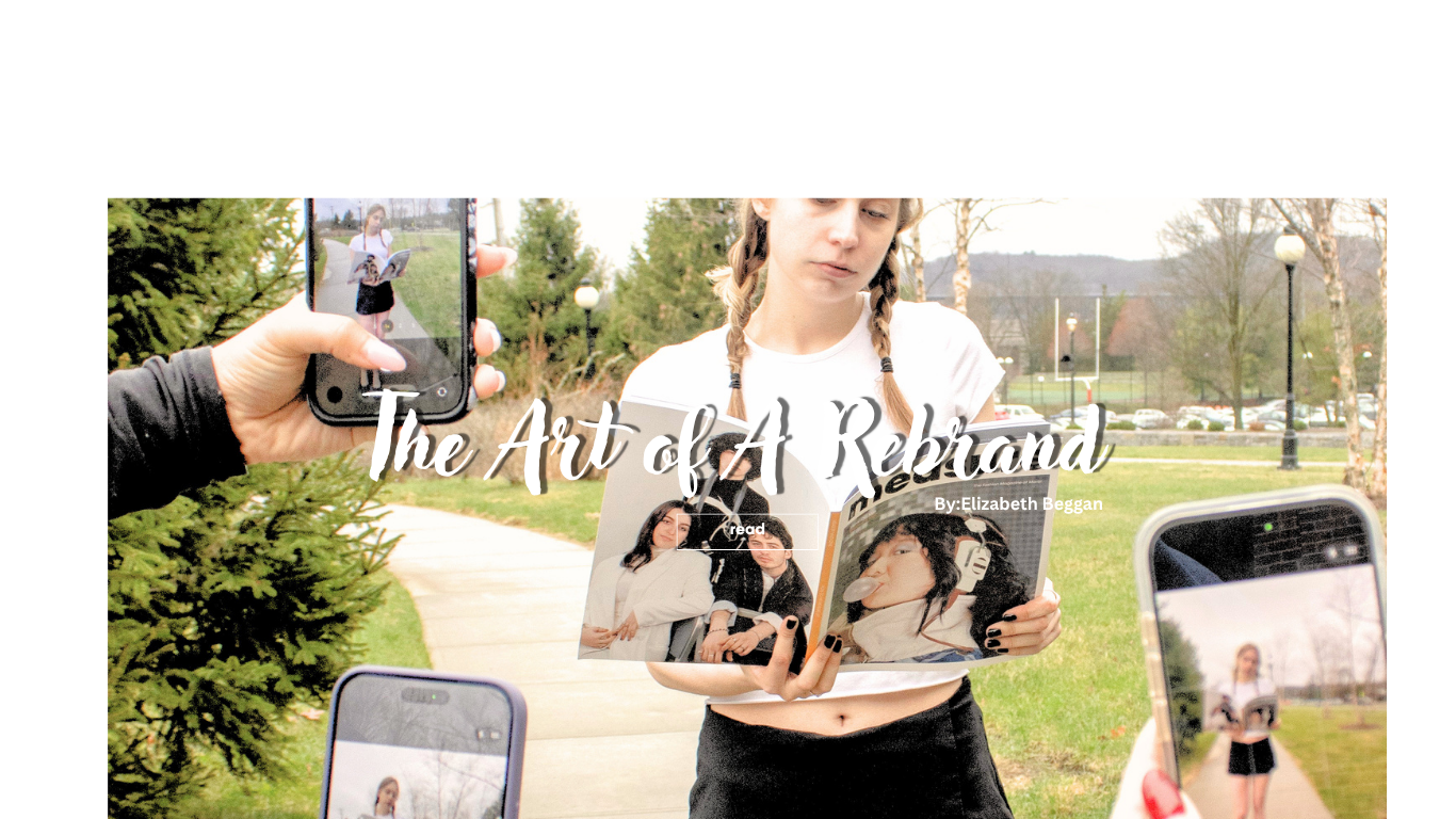 A young woman holds a magazine and is being photographed by multiple people using smartphones in an outdoor park with trees and grass.