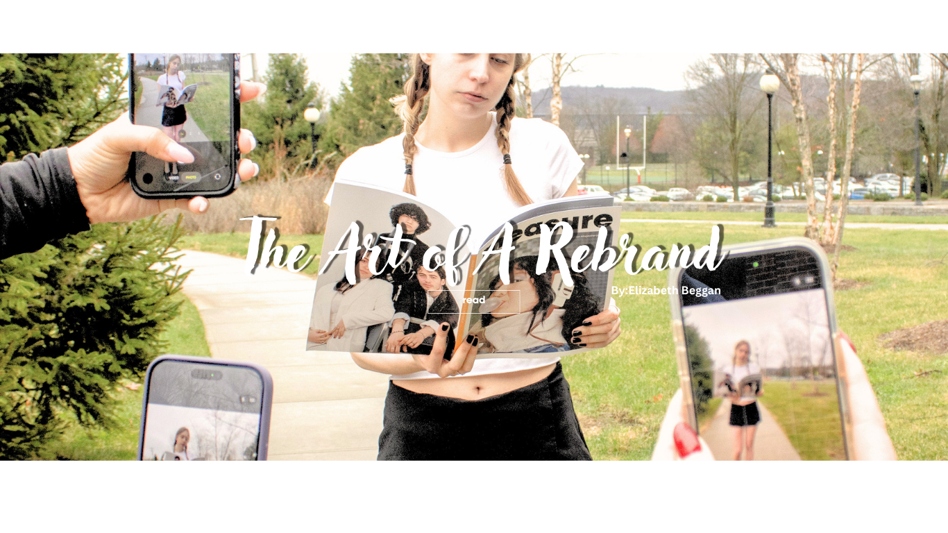 A girl with braided hair reading a magazine outdoors in a park, surrounded by people taking photos with their smartphones, with trees and park features in the background.