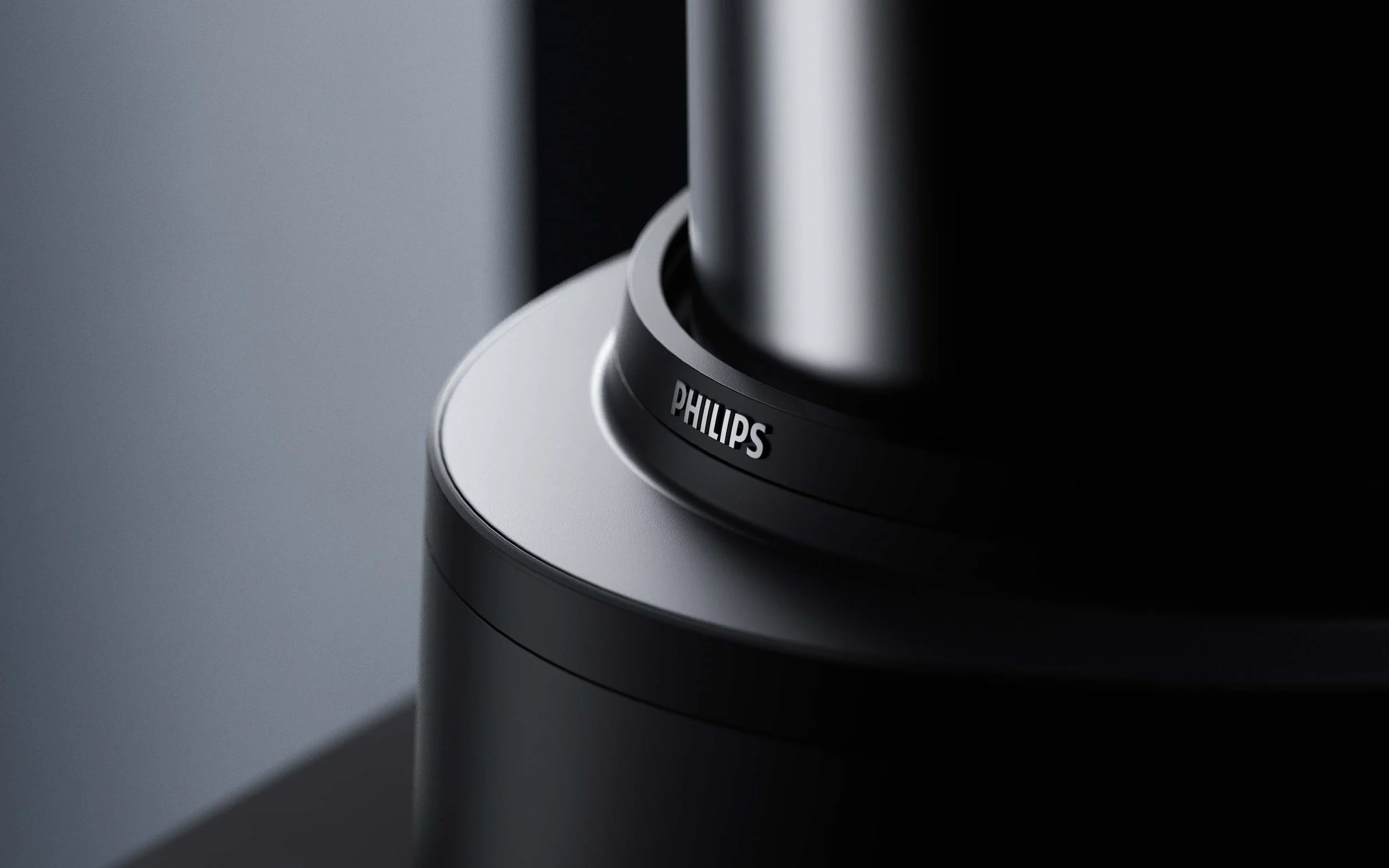 Nahaufnahme eines Philips-Produktes, wahrscheinlich ein Lautsprecher oder Küchengerät, mit silbernem und schwarzem Design, auf einer grauen Oberfläche