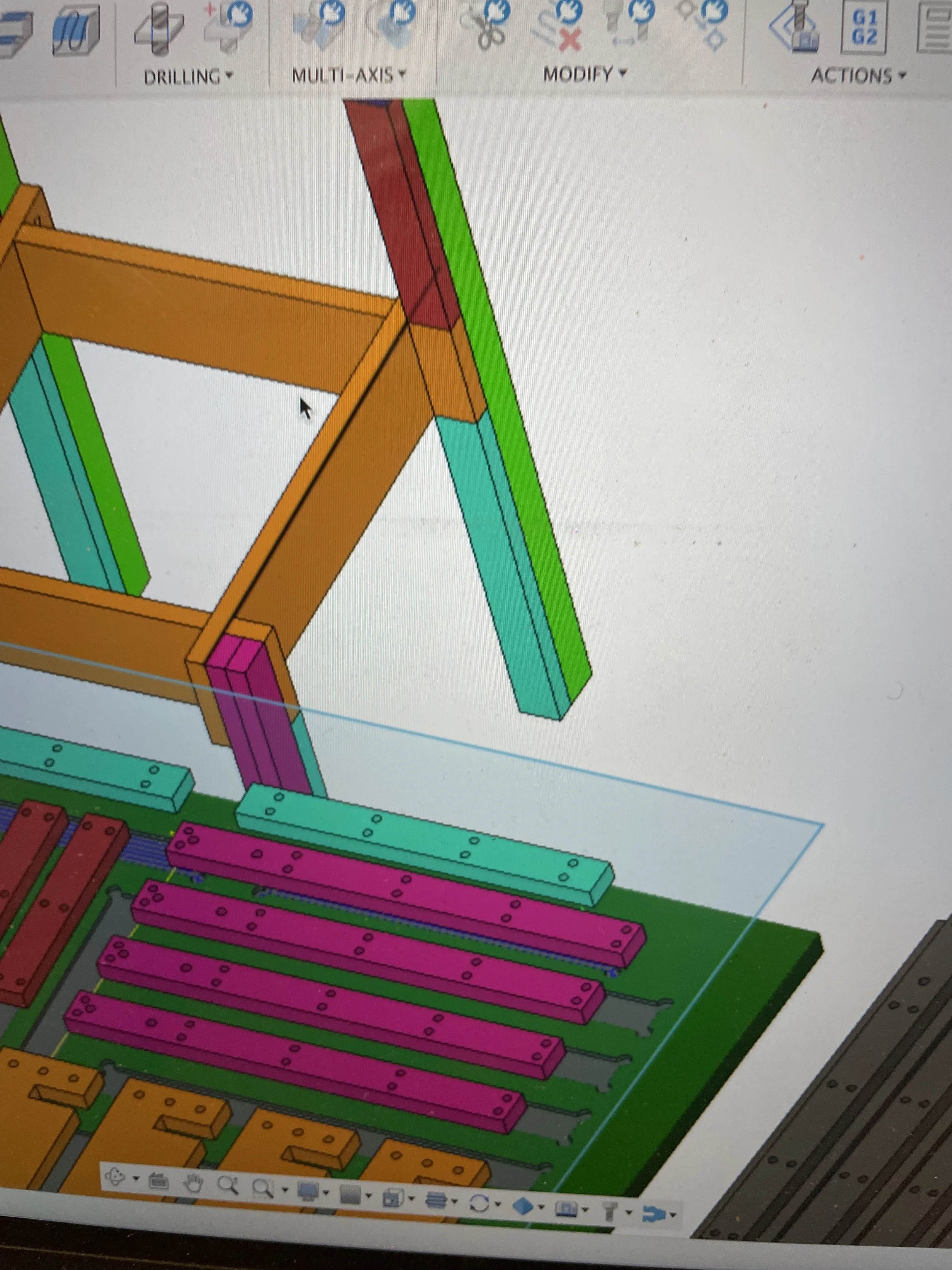 Skærmbillede af en computer, der viser en 3D-model af en bygning eller konstruktion i et CAD-program med farvede dele.