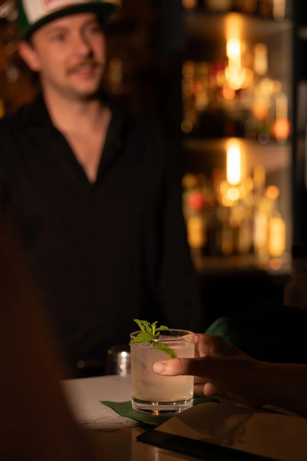 bartender's hands using a crystal mixing glass.