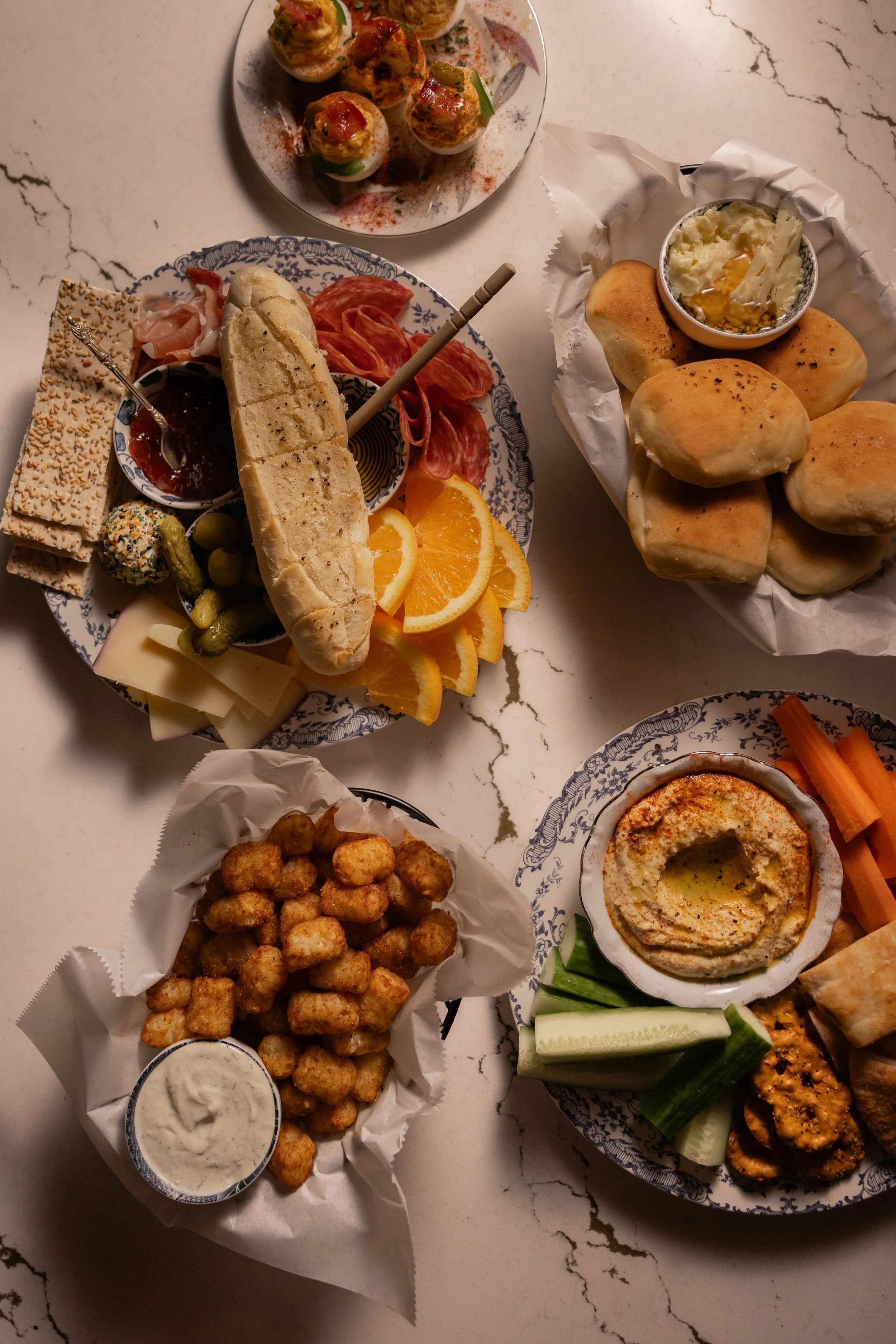 Curated spread of gourmet small plates including charcuterie, hummus with vegetables, and sliders on a marble table at 1854 Cocktail Bar & Lounge in Cookeville.