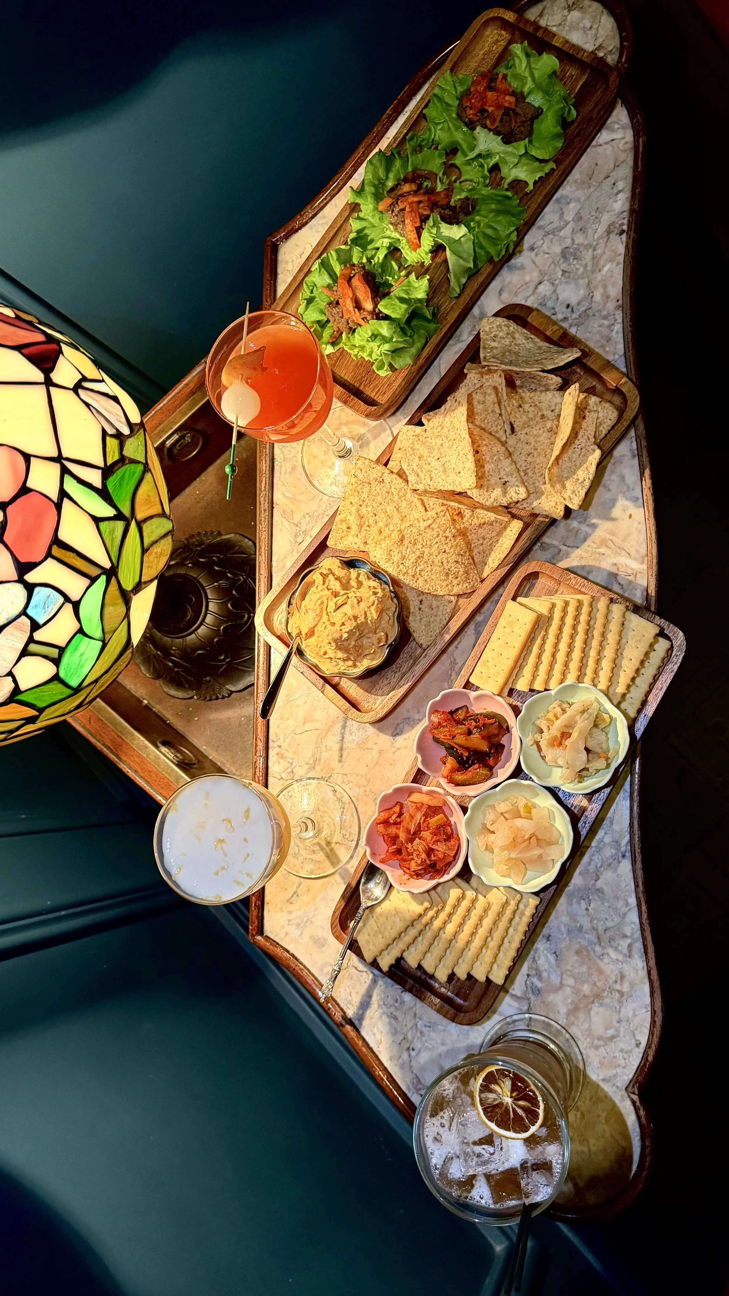 Overhead view of gourmet shareable plates, crackers, and house artisanal dips served on a wooden board at 1854 Cocktail Bar & Lounge in Cookeville TN.