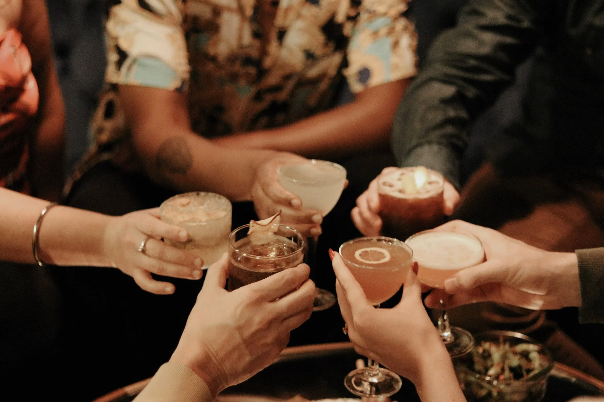Group of friends toasting craft cocktails at the bar in 1854 Cocktail Bar & Lounge in Cookeville TN.