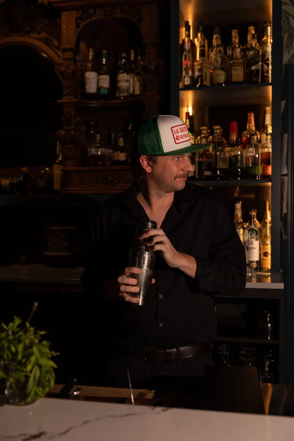 Carter, lead mixologist at 1854 Cocktail Bar & Lounge, crafting signature seasonal cocktails behind the bar in Cookeville TN.