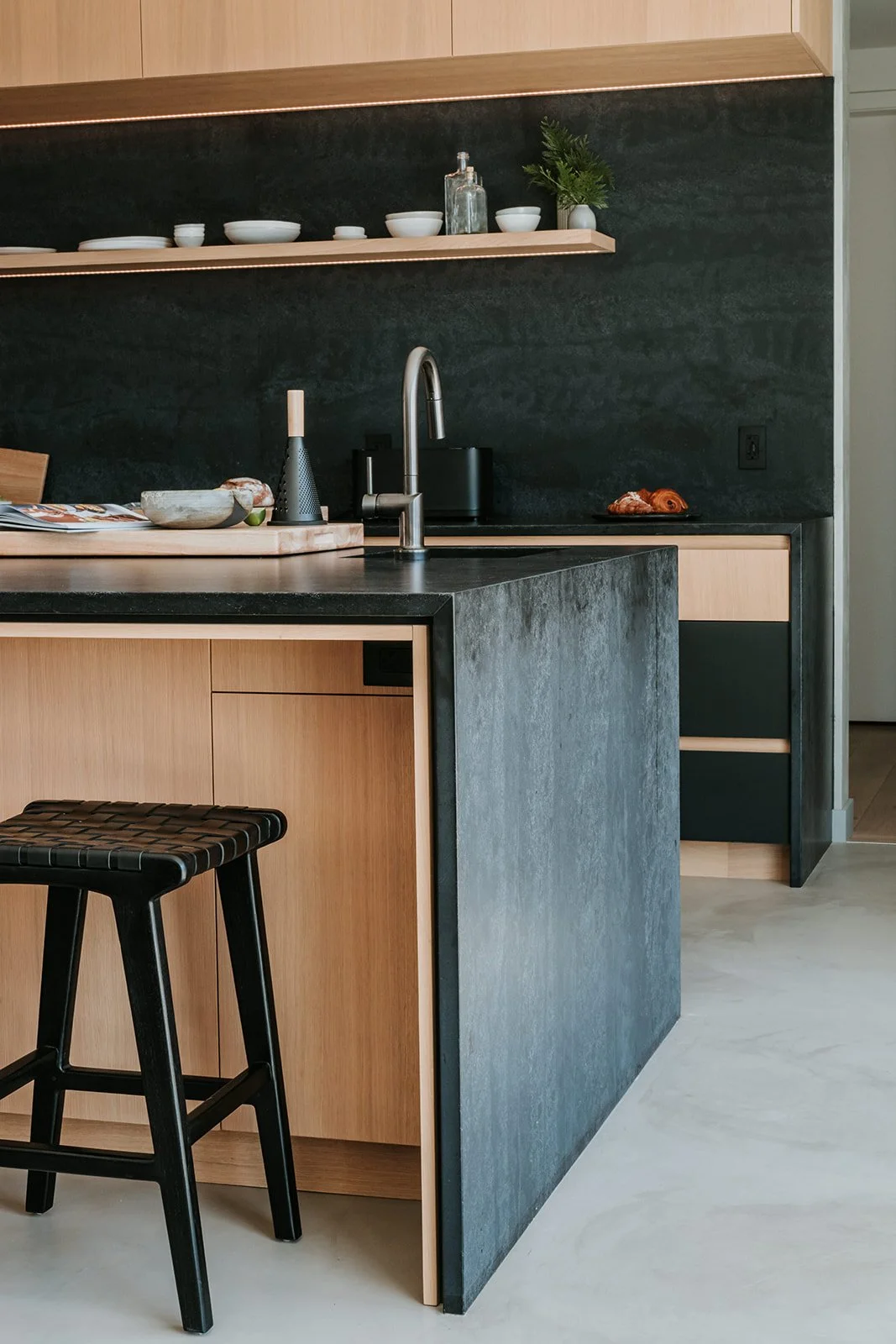 Sunstone Kitchen island end detail showing dark stone waterfall edge — new-build interior design in Pemberton, BC by LRD Studio. Photography by Darby Magill.