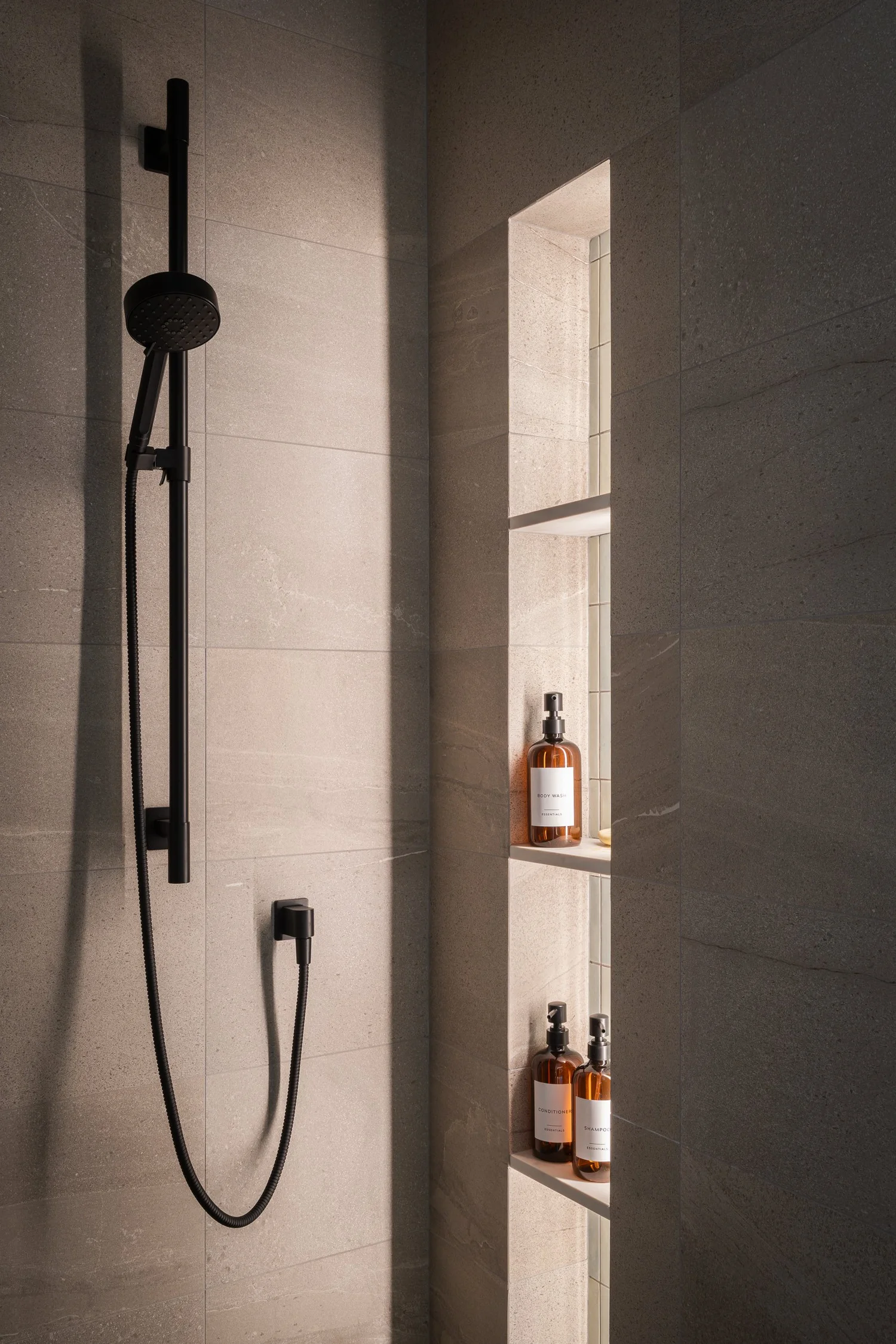 Tapleys Ensuite wide view with black Carmana stone and underlit niches — full renovation interior design in Whistler, BC by LRD Studio. Photography by Matt Anthony.
