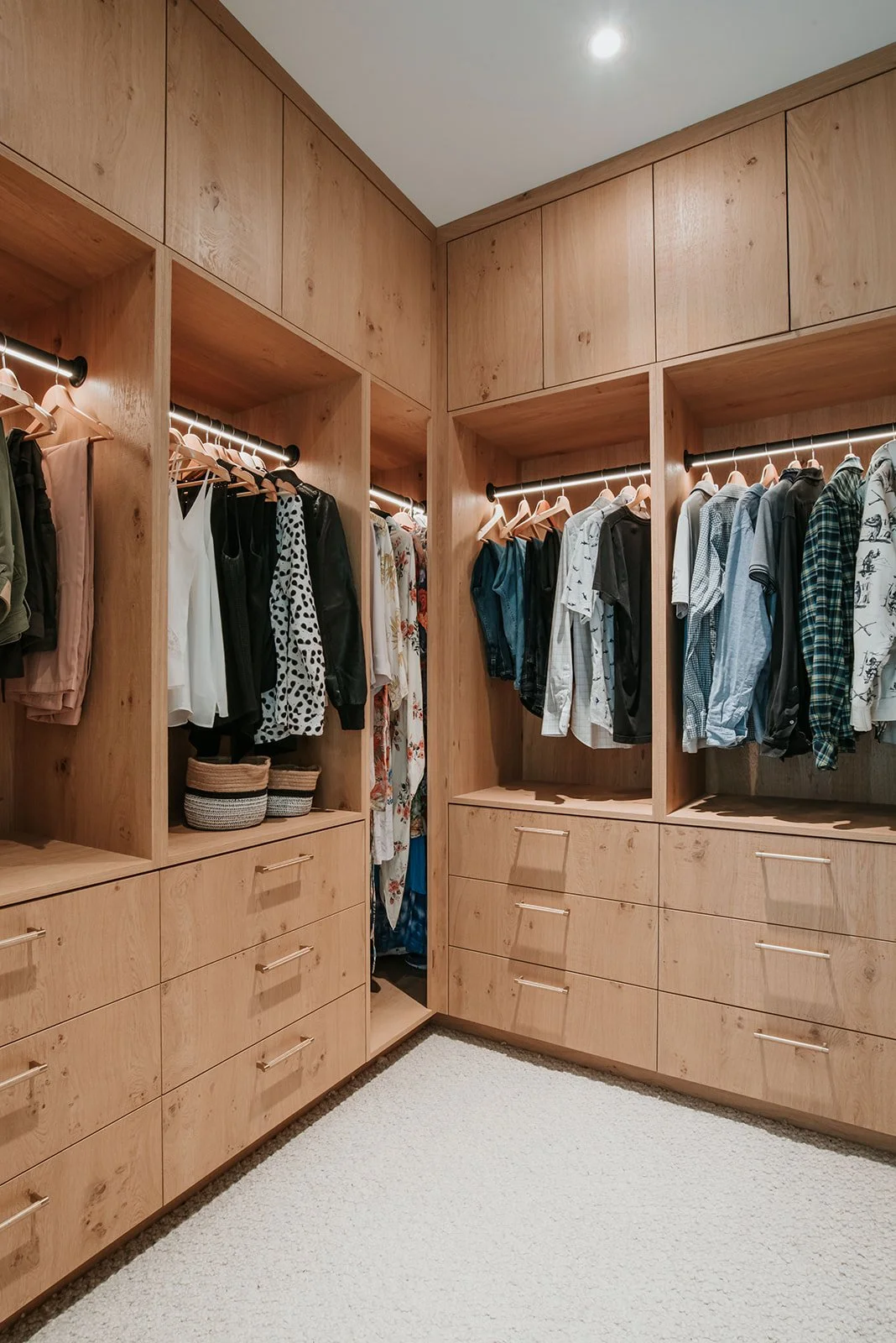 Balsam Open concept oak wardrobe, underlit hanging rods, full of clothes, drawers below — new-build interior design in Whistler, BC by LRD Studio. Photography by Darby Magill.