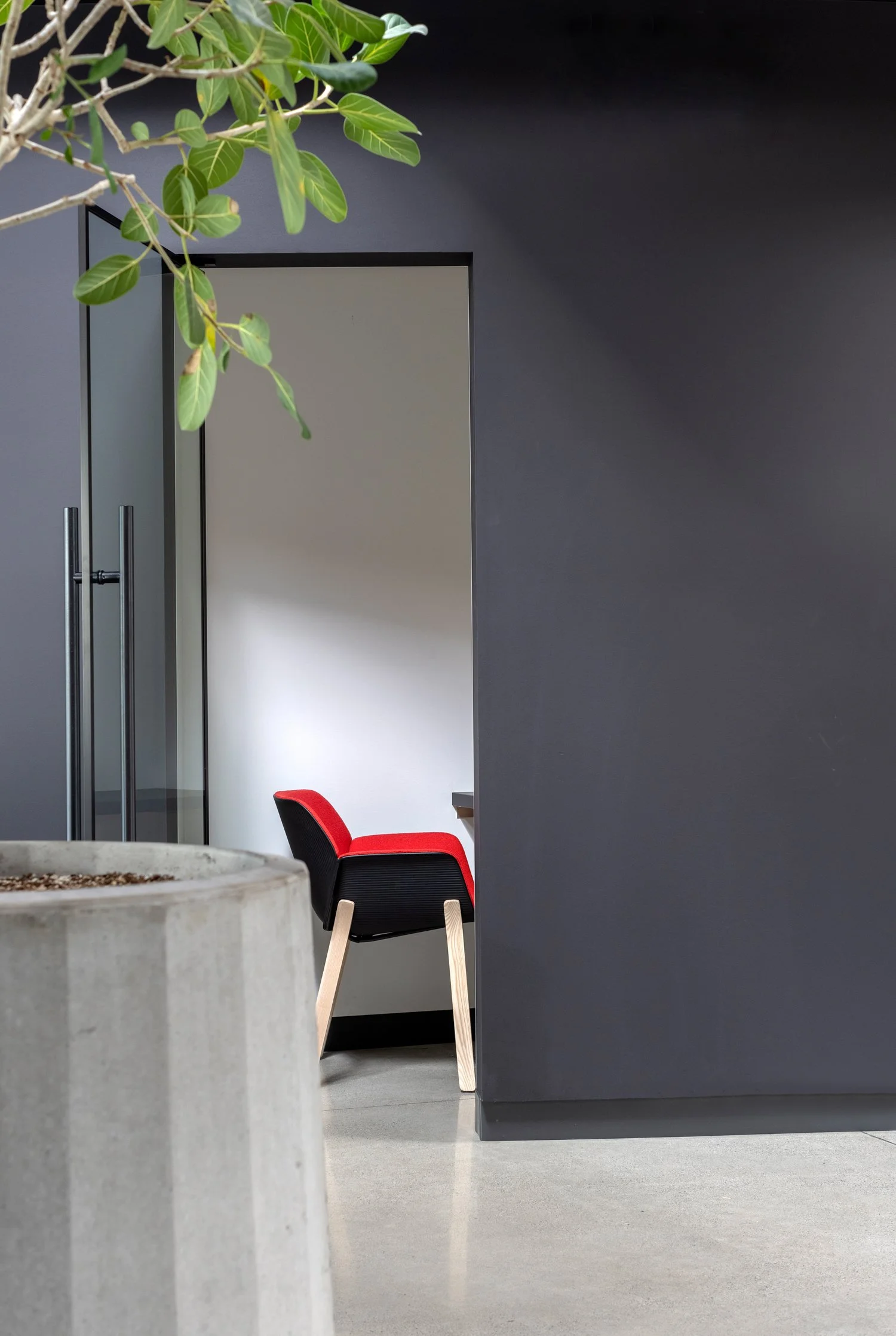 SRAM Glass-walled curved meeting room with geometric recycled vinyl flooring, commercial interior design in North Vancouver, BC by LRD Studio. Photography by Janis Nicolay.