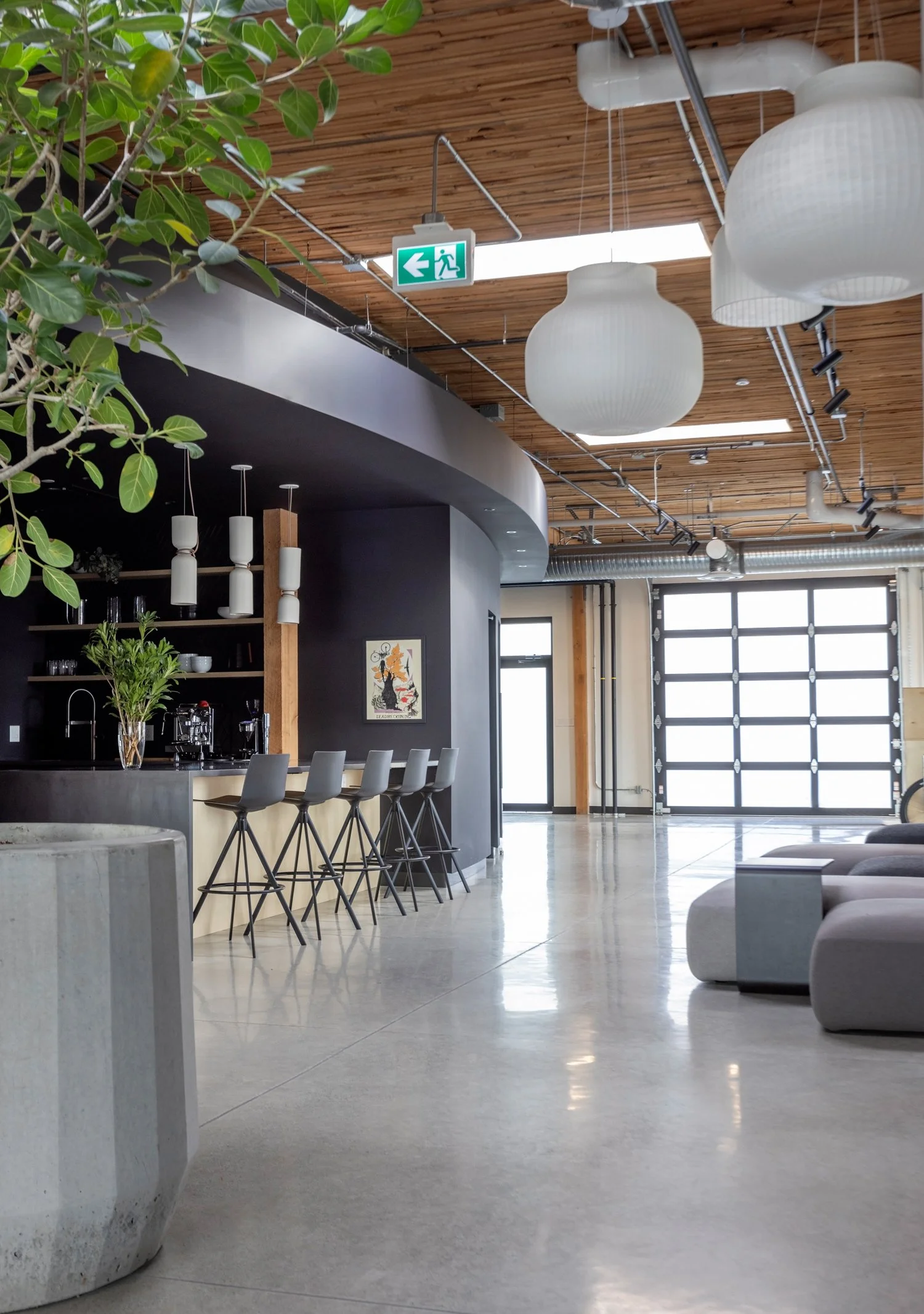 SRAM Inside curved meeting room, grey task chair on geometric vinyl floor, TV mounted, commercial interior design in North Vancouver, BC by LRD Studio. Photography by Janis Nicolay.