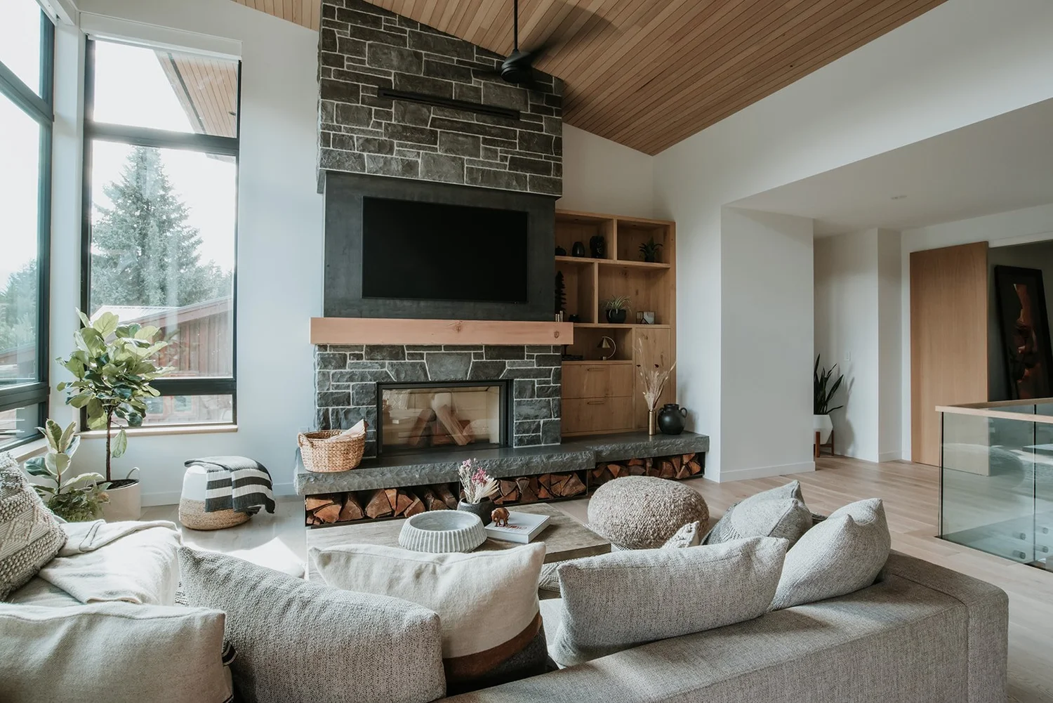 Balsam Wide view: Kingston slate fireplace, vaulted cedar ceiling, sectional, fiddle leaf fig — new-build interior design in Whistler, BC by LRD Studio. Photography by Darby Magill.