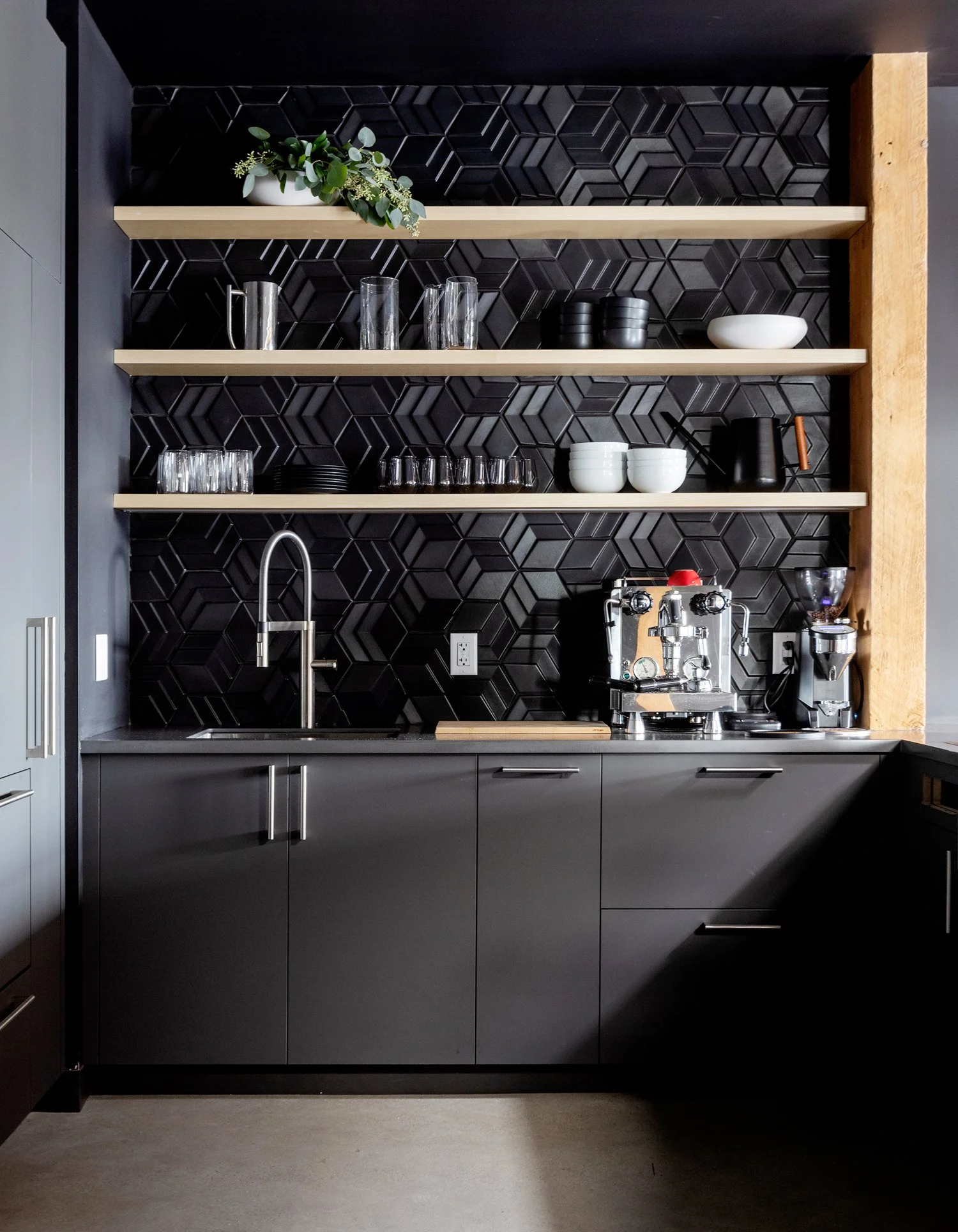 SRAM Black cabinetry wall with five black swivel stools at oak-front island, commercial interior design in North Vancouver, BC by LRD Studio. Photography by Janis Nicolay.
